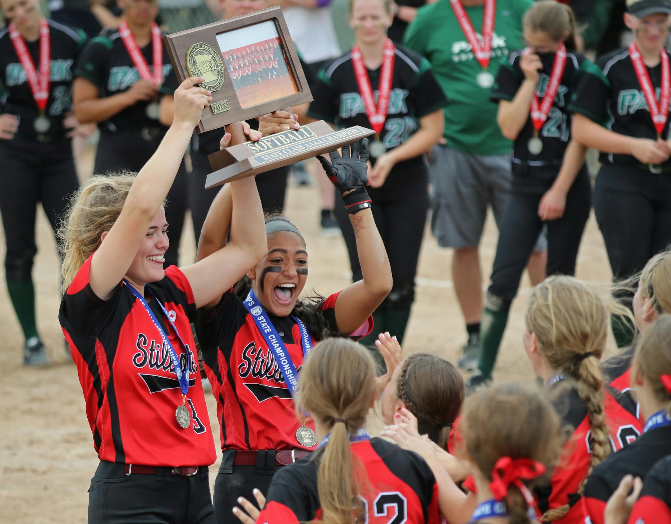 The Stillwater Ponies celebrated their 4A title after defeating the Wolfpack from Park of Cottage Grove 5-1. In this photo, captains Alex Ehde (left) and Tatiana Tabucol (right) deliver the state championship trophy to their team. ] Shari L. Gross • shari.gross@startribune.com The Minnesota State High School League's girls' softball state tournament championship games were played Friday, June 8, 2018 at Caswell Park in North Mankato. Class 4A: The Stillwater Ponies defeated the Wolfpack f