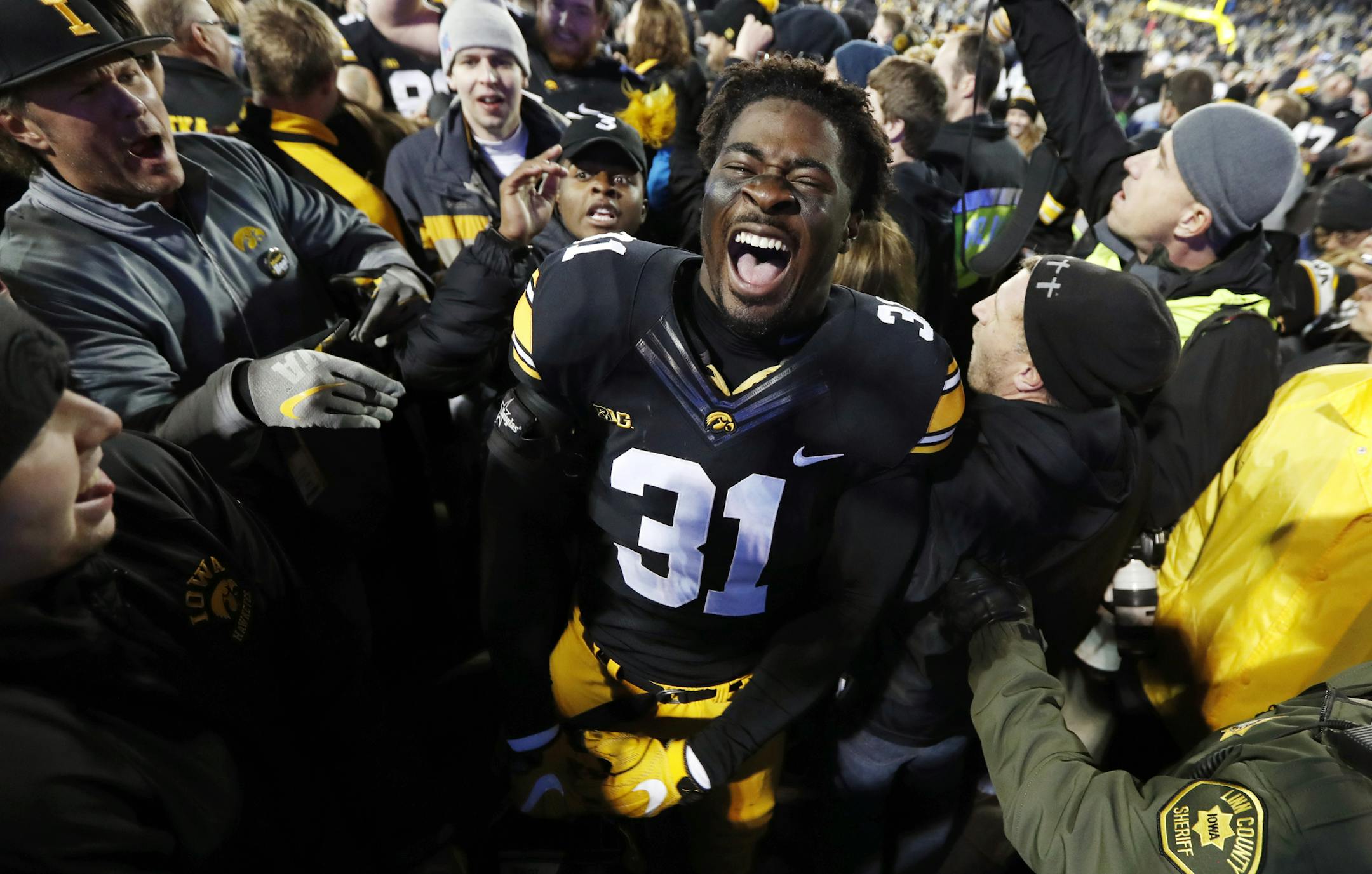 Iowa linebacker Aaron Mends celebrates with fans after an NCAA college football game against Michigan, Saturday, Nov. 12, 2016, in Iowa City, Iowa. Iowa won 14-13. (AP Photo/Charlie Neibergall)
