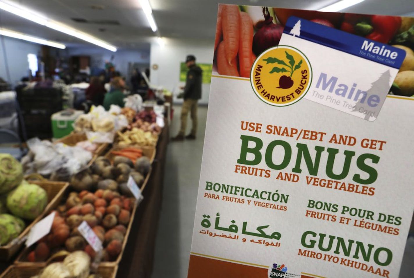 A sign advertises a program that allows food stamp recipients to use their EBT cards to shop at a farmer's market in Topsham, Maine, in March. President Donald Trump's administration is proposing to end an option that has allowed states to exceed federal eligibility thresholds for food stamps.