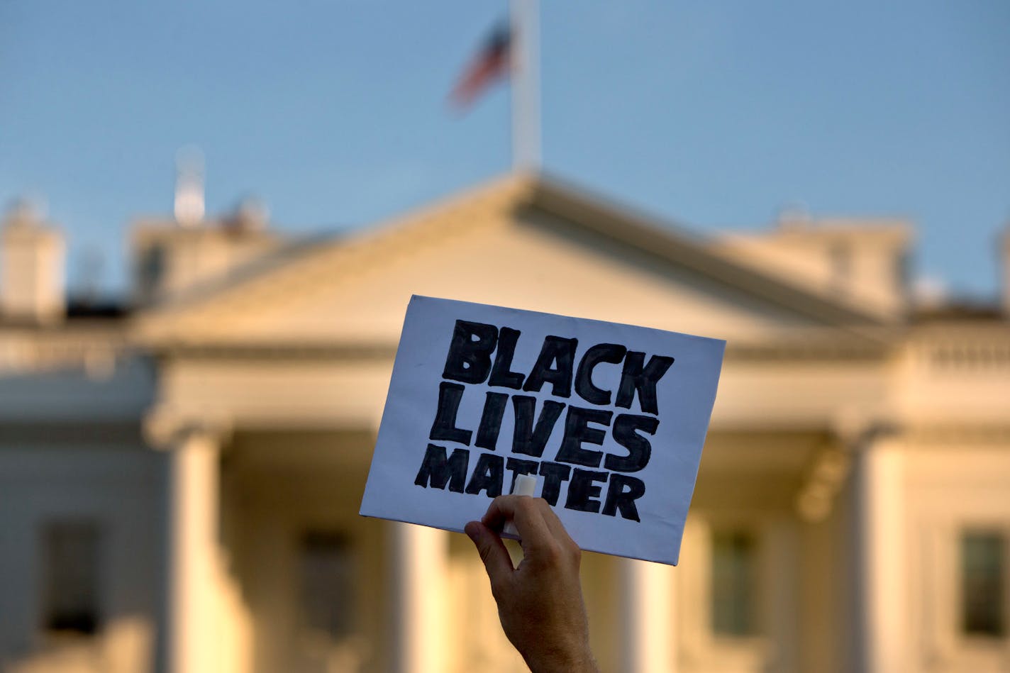 FILE - In this July 8, 2016 file photo, a man holds up a sign saying "black lives matter" during a protest of shootings by police, at the White House in Washington. Black social media users are nearly twice as likely to see posts about race and race relations as whites, according to a report released Monday, Aug. 15, 2016, by the Pew Research Center. (AP Photo/Jacquelyn Martin)