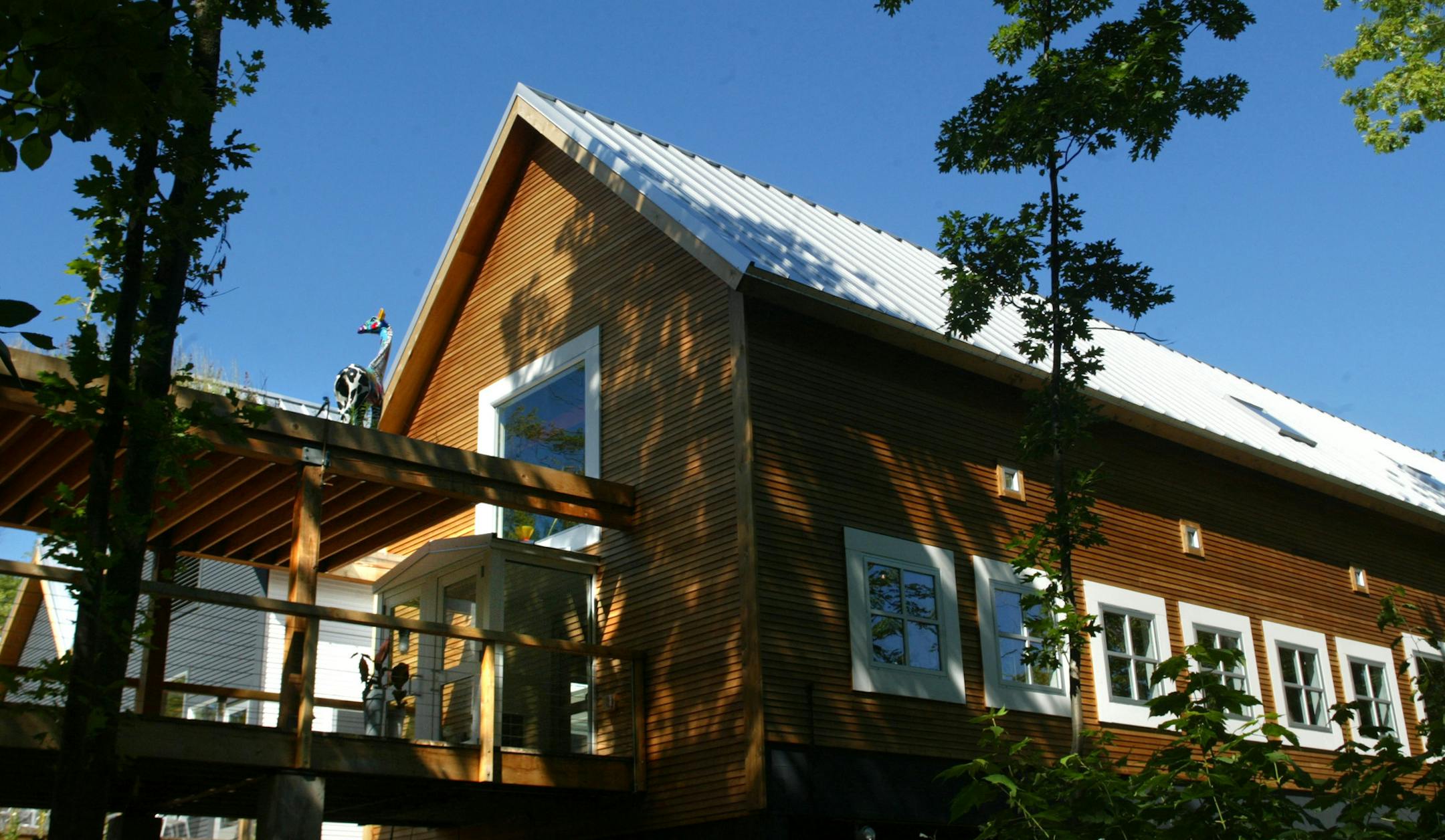 Bayfield Wisconsin 8/3/2002-- Wild Rice restaurant. A look at the main dining room with it's entry and covered walkway fom the woods and lakeside. the giraffe is visible on the top of the walkway standing in the planted wild grasses....the hippo is just out of sight.