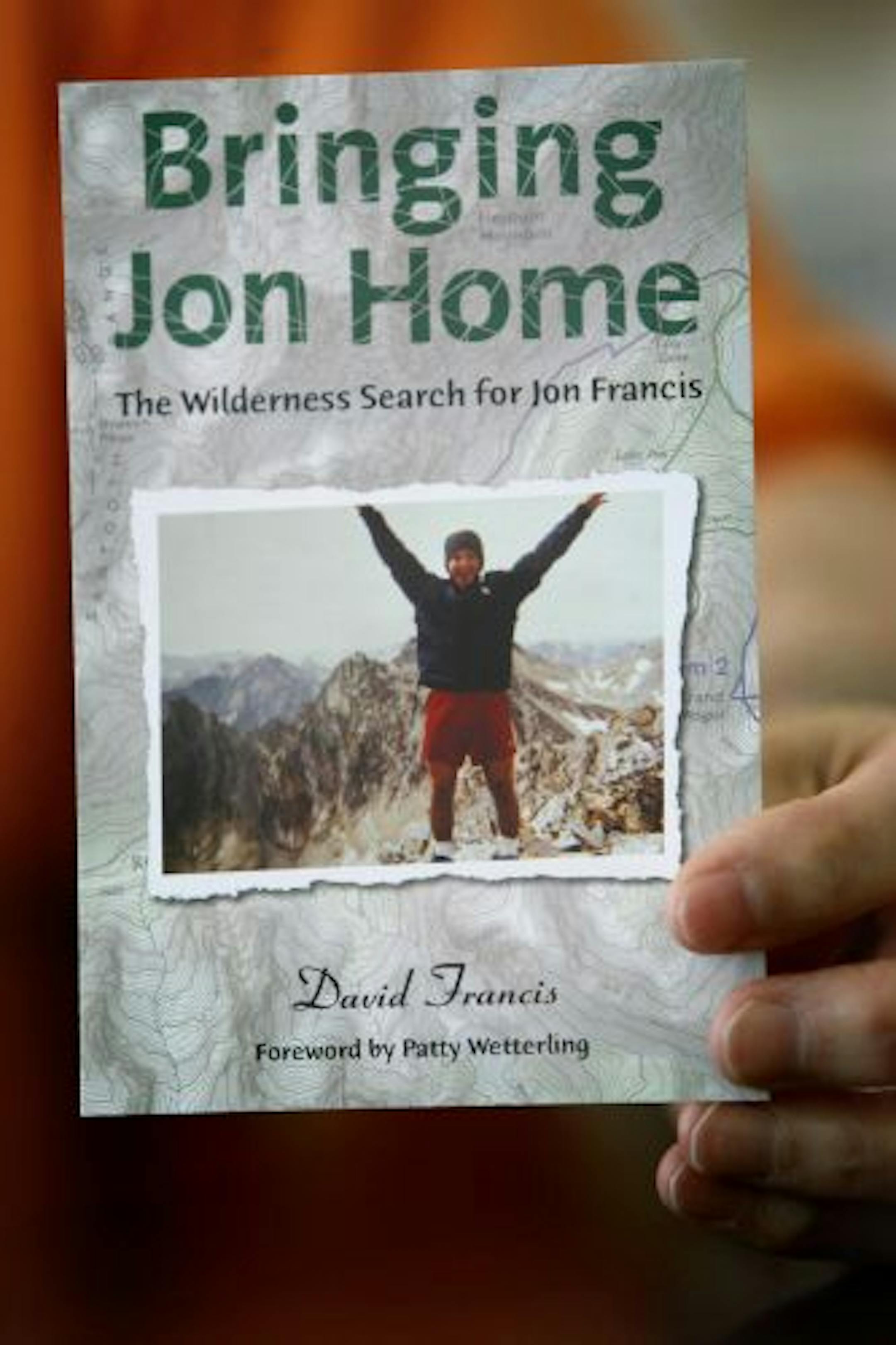 David Francis held up a postcard for a book opening that he will soon have for the book he wrote about his son Jonathan David Francis after he went missing.