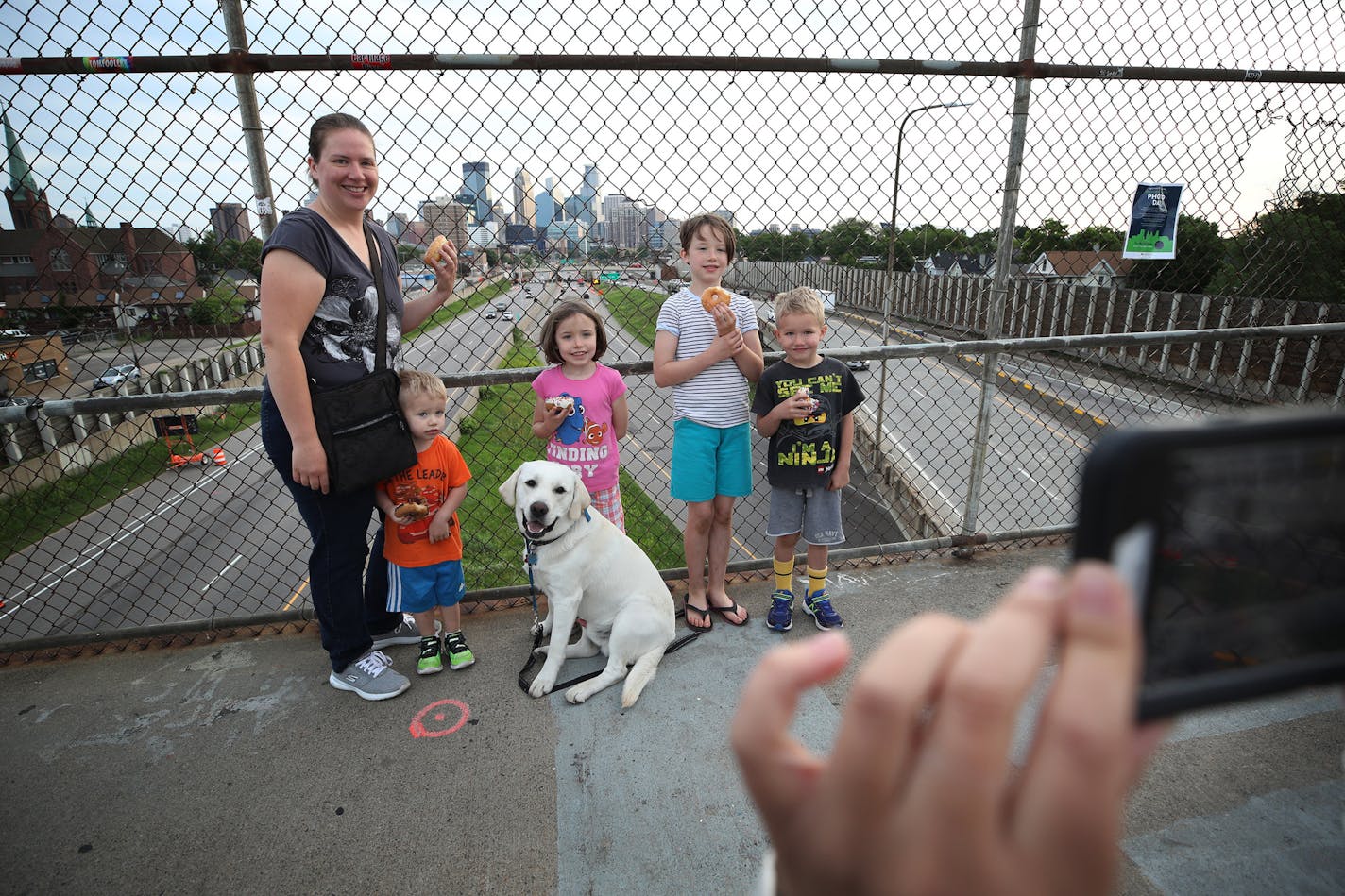 Cassie Stiles and her kids Samuel 2, Danielle 7, Isabelle 9, Gabriel 5, and there dog Toby were among a few people who gathered on the 24th street pedestrian bridge to get a glimpse and photograph the Minneapolis Skyline Thursday morning June 7, 2018 in Minneapolis, MN. ] A new bridge will be constructed as part of the crosstown project. JERRY HOLT &#xef; jerry.holt@startribune.com