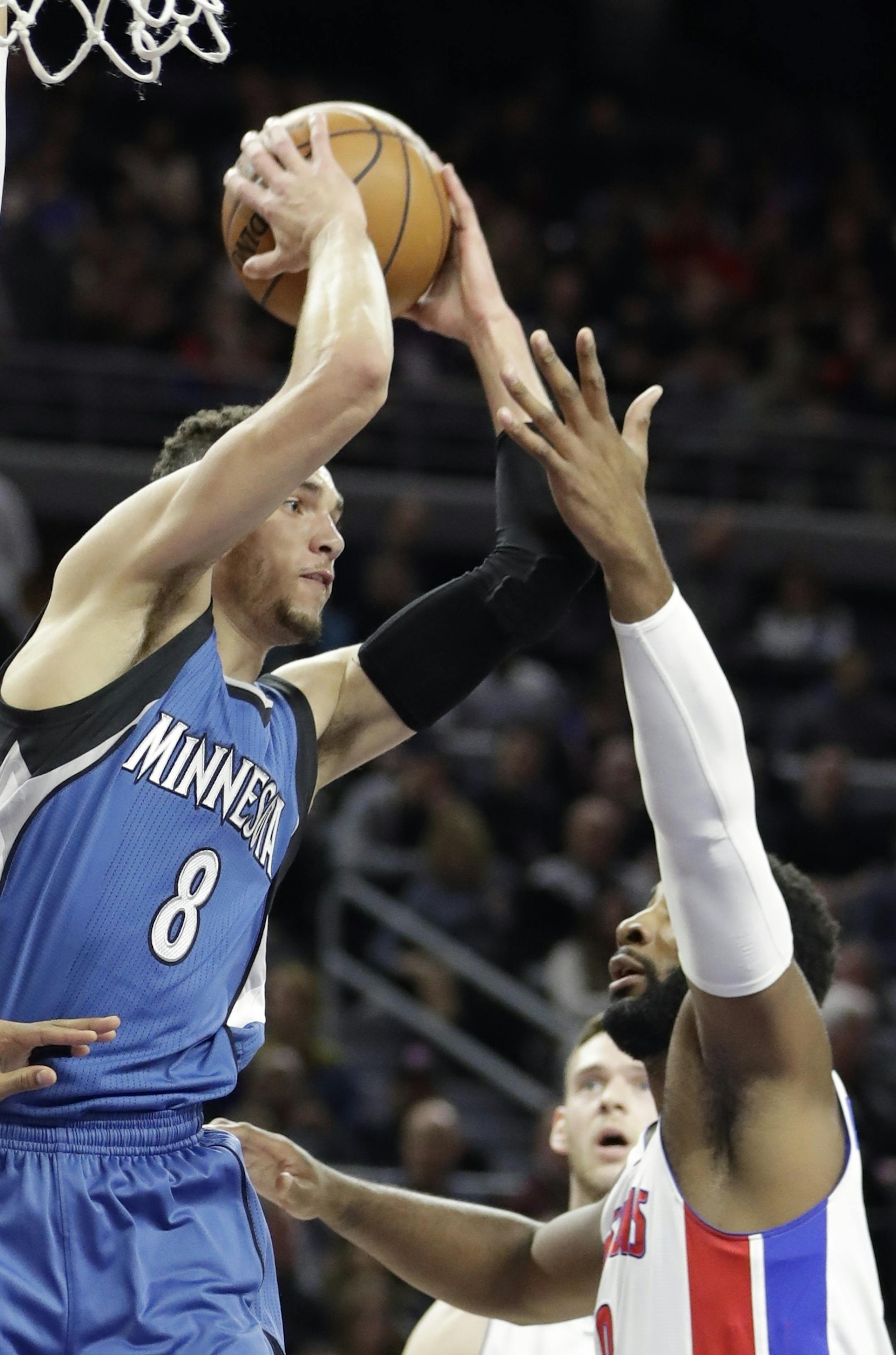 Minnesota Timberwolves guard Zach LaVine (8) passes the ball as Detroit Pistons forward Tobias Harris (34) and center Andre Drummond, right, close in during the first half of an NBA basketball game, Friday, Feb. 3, 2017, in Auburn Hills, Mich. (AP Photo/Carlos Osorio)