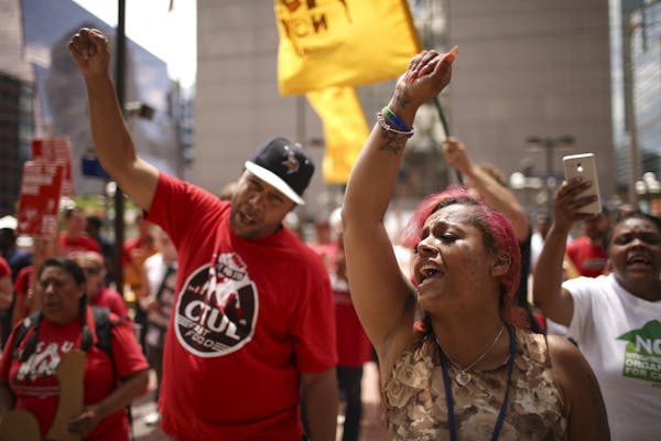Supports of a $15 minimum wage chanted as they rallied before marching around City Hall and delivering the petition.