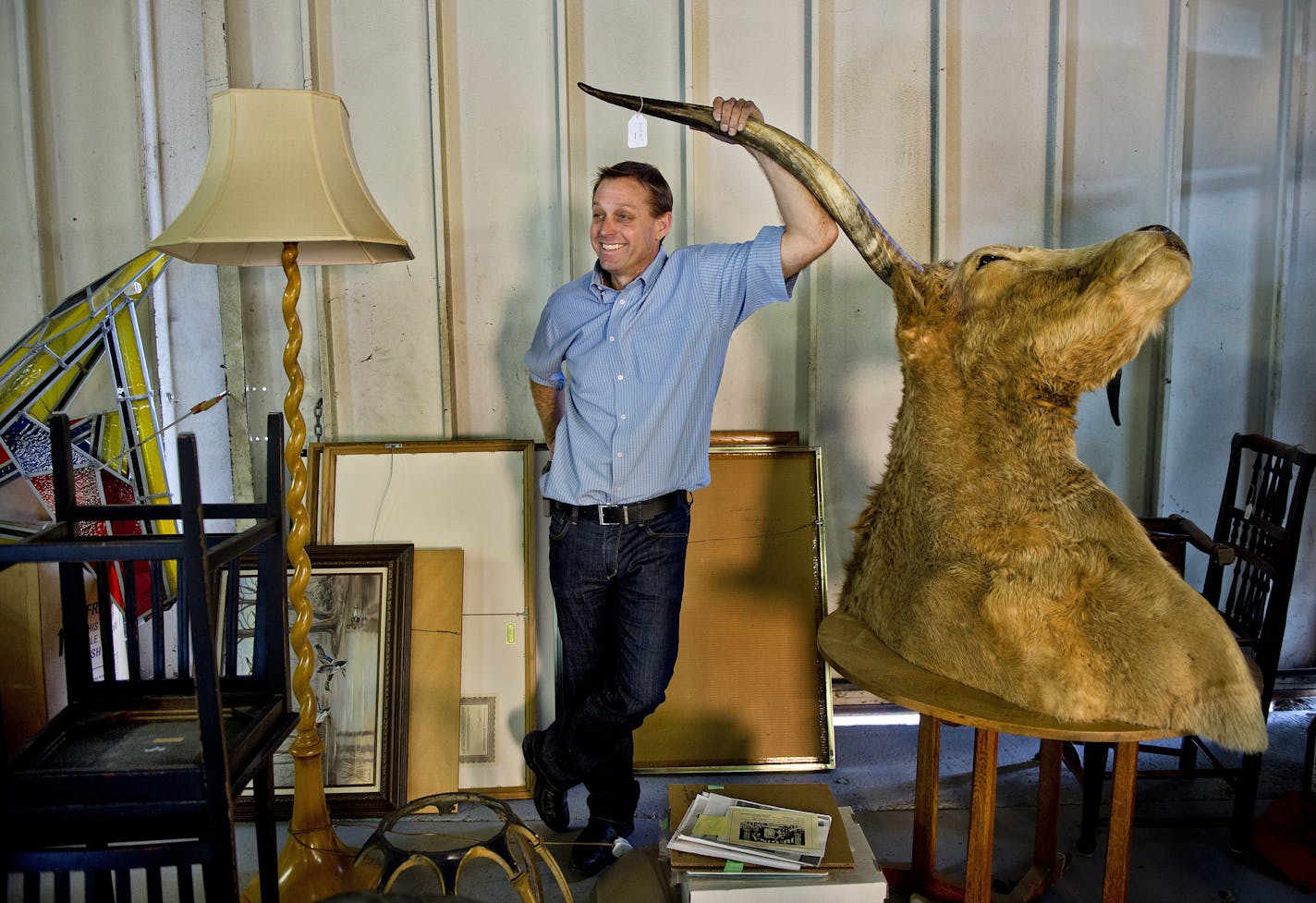 Brian Witherell rests on the horn of an ox while chatting about different California antiques in his warehouse in Sacramento. (Renee C. Byer/Sacramento Bee/TNS) ORG XMIT: 1215828