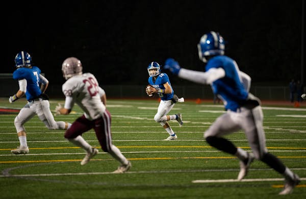 Woodbury quarterback George Bjellos (16) spotted his intended target, receiver Joey Gerlach (6), right, before tossing him a fourth quarter touchdown 