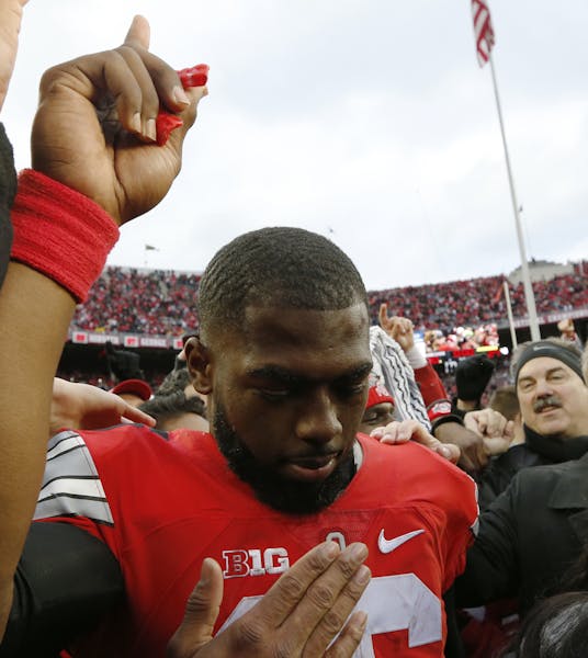 Ohio State quarterback J.T. Barrett celebrates with fans after their win over Michigan in an NCAA college football game Saturday, Nov. 26, 2016, in Co