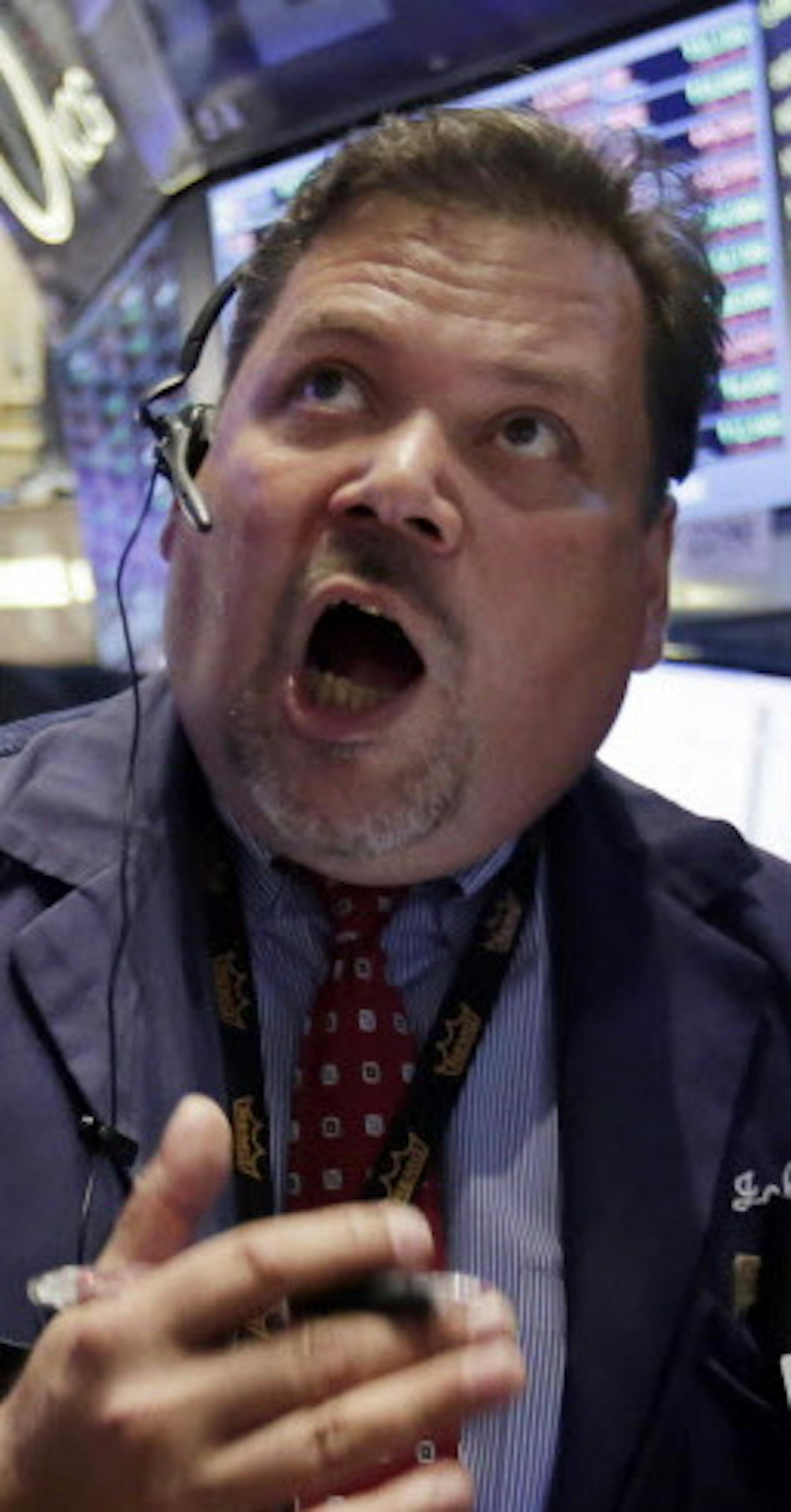 Trader John Santiago, center, works on the floor of the New York Stock Exchange, Monday, Aug. 24, 2015. U.S. stock markets plunged in early trading Monday following a big drop in Chinese stocks. (AP Photo/Richard Drew)