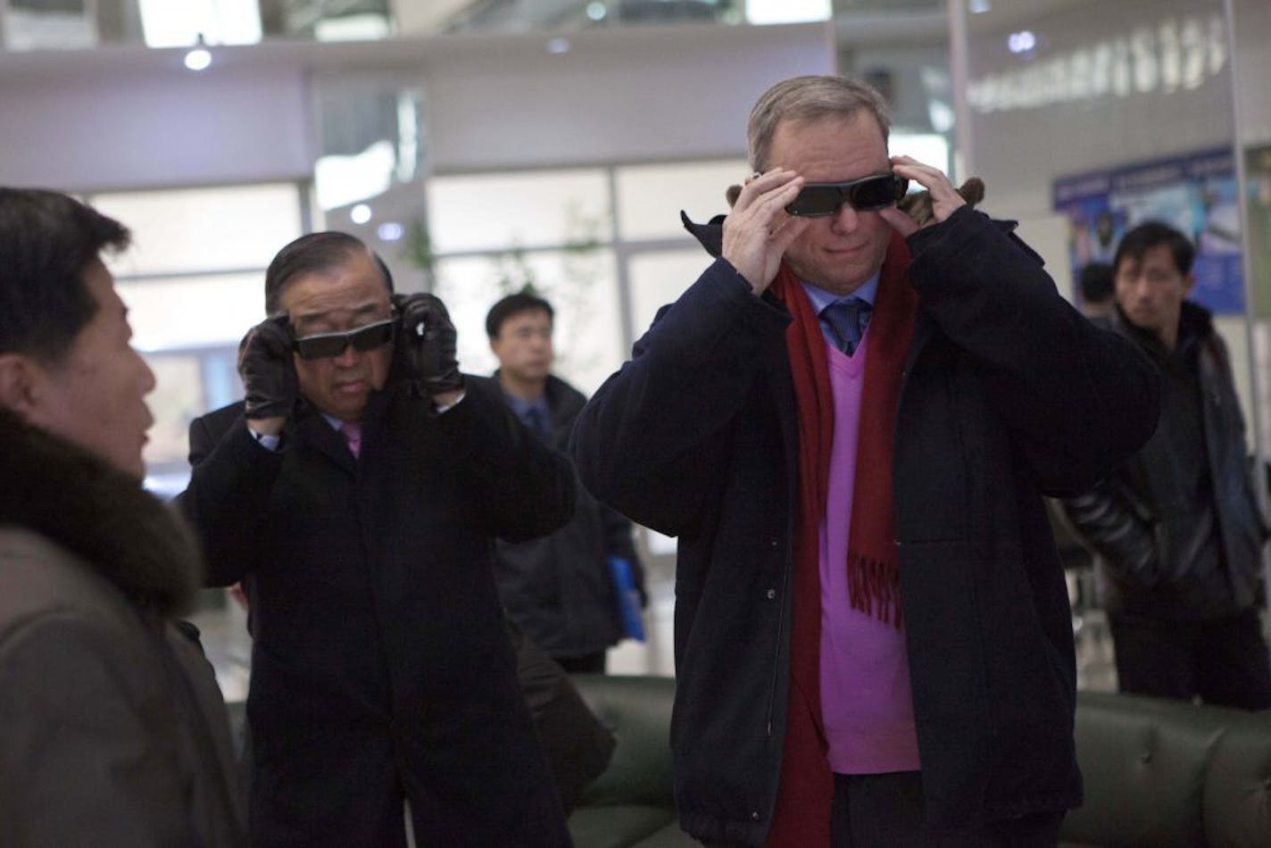 Executive Chairman of Google, Eric Schmidt, right, tries on 3-D glasses as he looks at North Korean-developed computer technology during a tour of the Korean Computer Center in Pyongyang, North Korea on Wednesday, Jan. 9, 2013. At left is Kun "Tony" Namkung, a North Korea's expert and member of the traveling delegation.