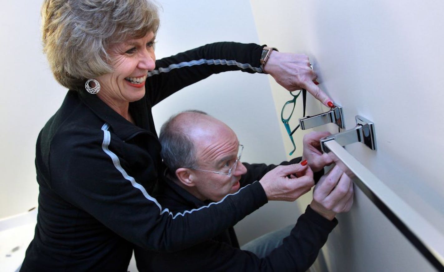 While waiting for their sons, Lee and Karen Newcomer worked on putting up towel racks in the upstairs bathroom.