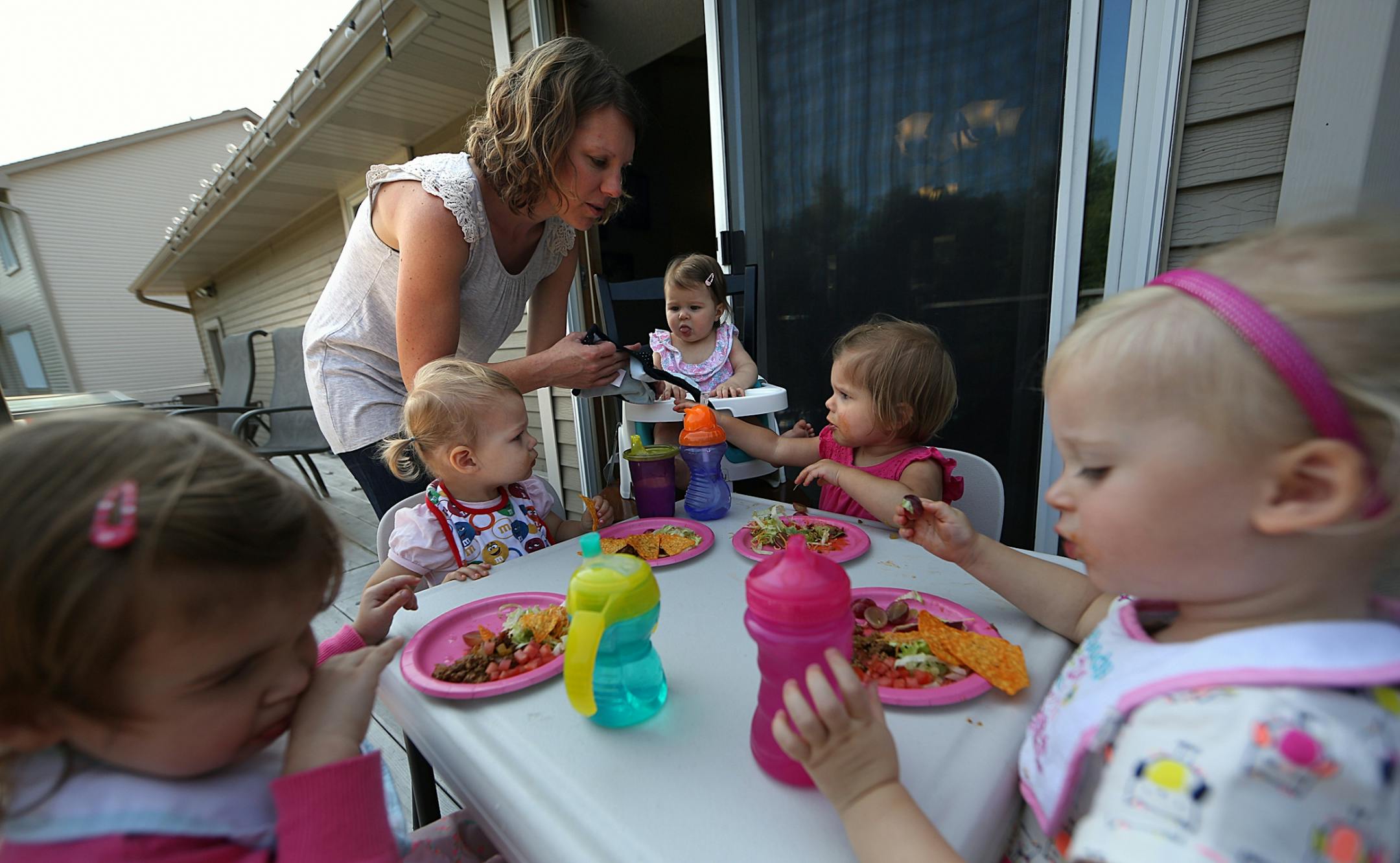 Children sat at a small table for lunch outside on a deck during the playdate (parent is Amy Korkki).
