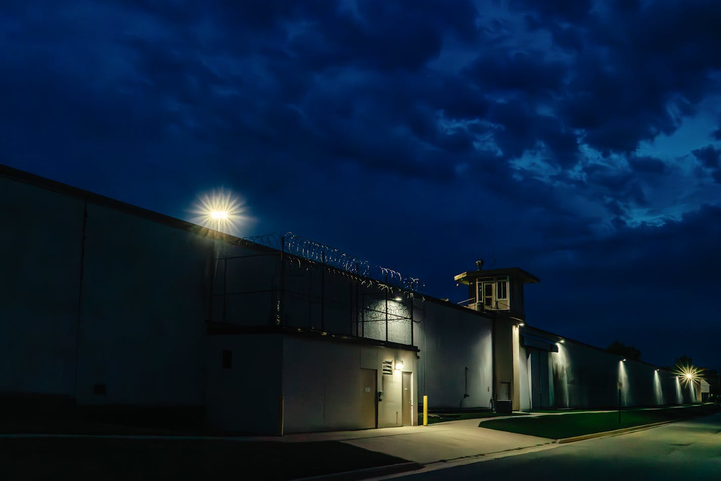 View of Waupun Correctional Institution in shadows at night with dark blue sky.