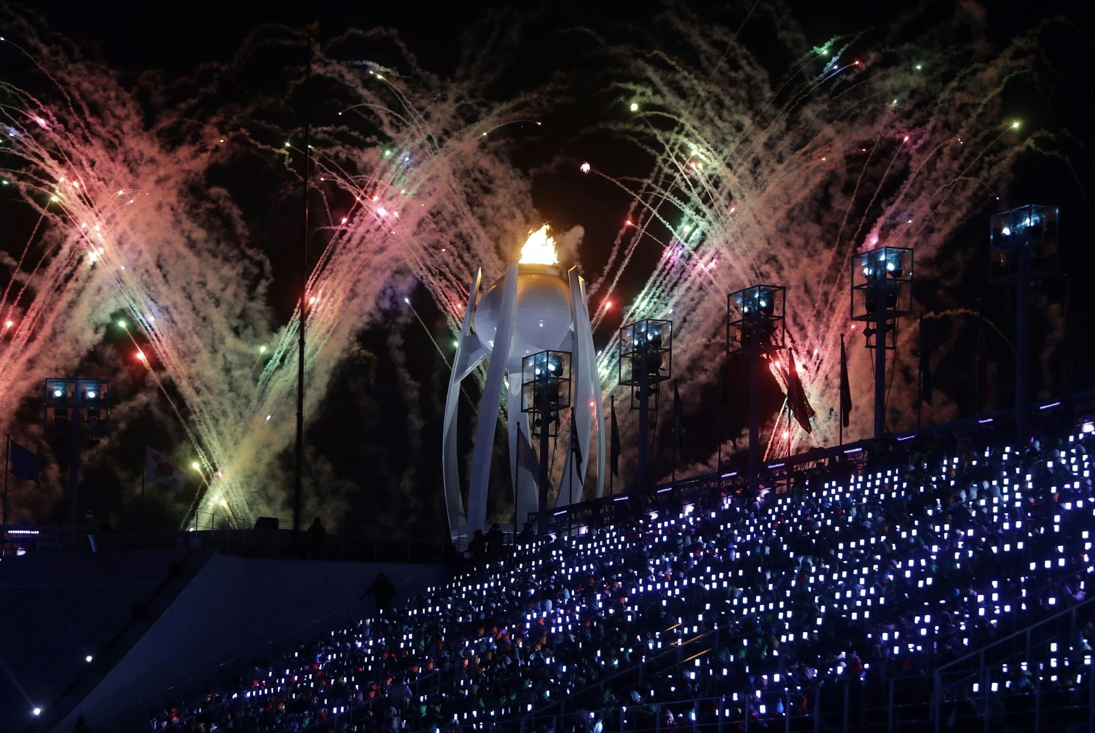 Fireworks explode over the Olympic flame during the closing ceremony of the 2018 Winter Olympics in Pyeongchang, South Korea, Sunday, Feb. 25, 2018.