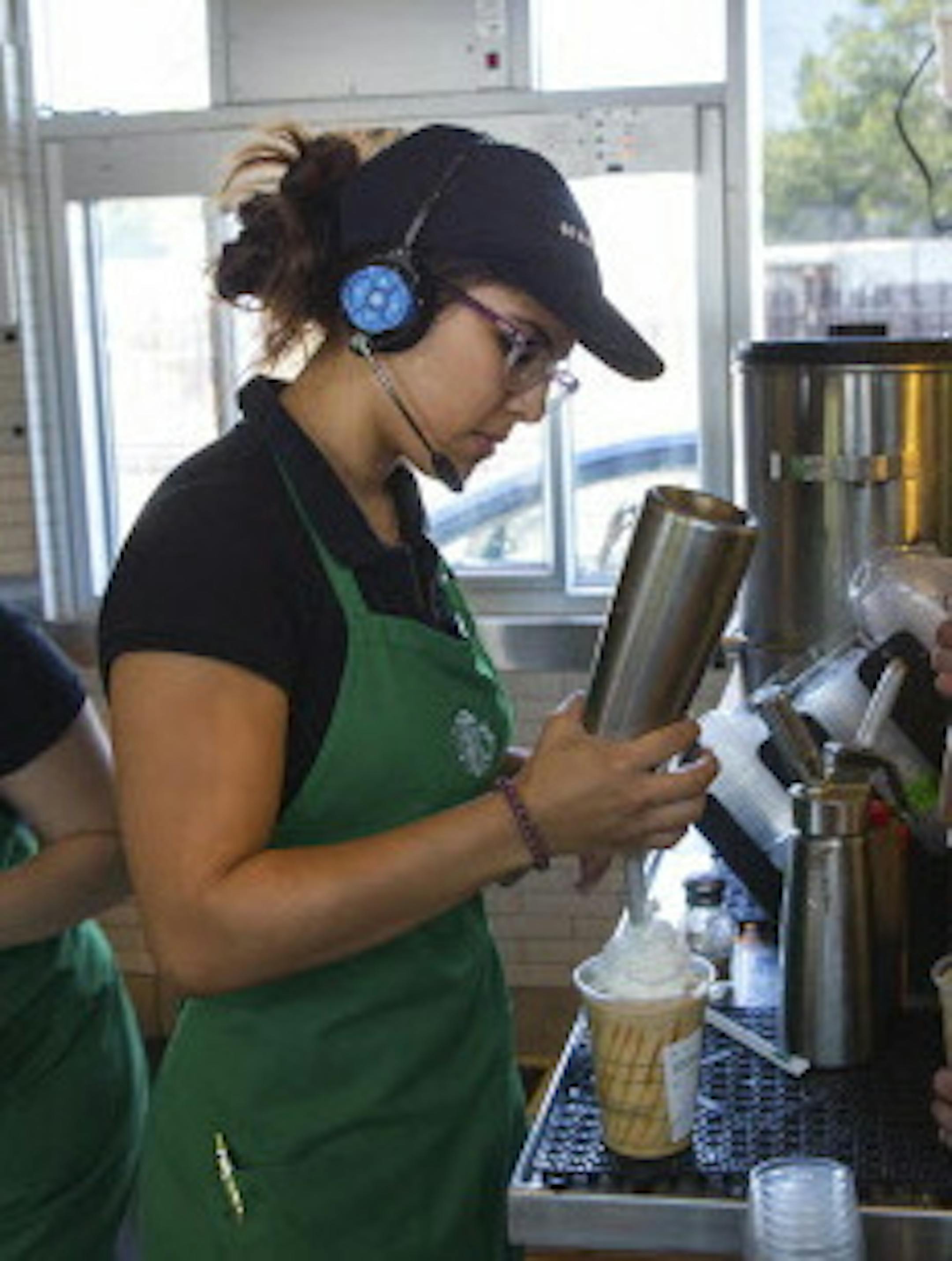 Tammie Lopez, center, who works a full-time job at Starbucks and attends community college at night, works her shift in San Fernando, Calif., June 13, 2014. Through an unusual arrangement with Arizona State University, Starbucks will provide free, online college education to thousands of its workers -- without requiring they remain with the company. (Monica Almeida/The New York Times)