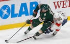 Florida Panthers' Jared McCann, right, tries to reach the puck as he pursues Minnesota Wild's Zach Parise during the first period of an NHL hockey gam