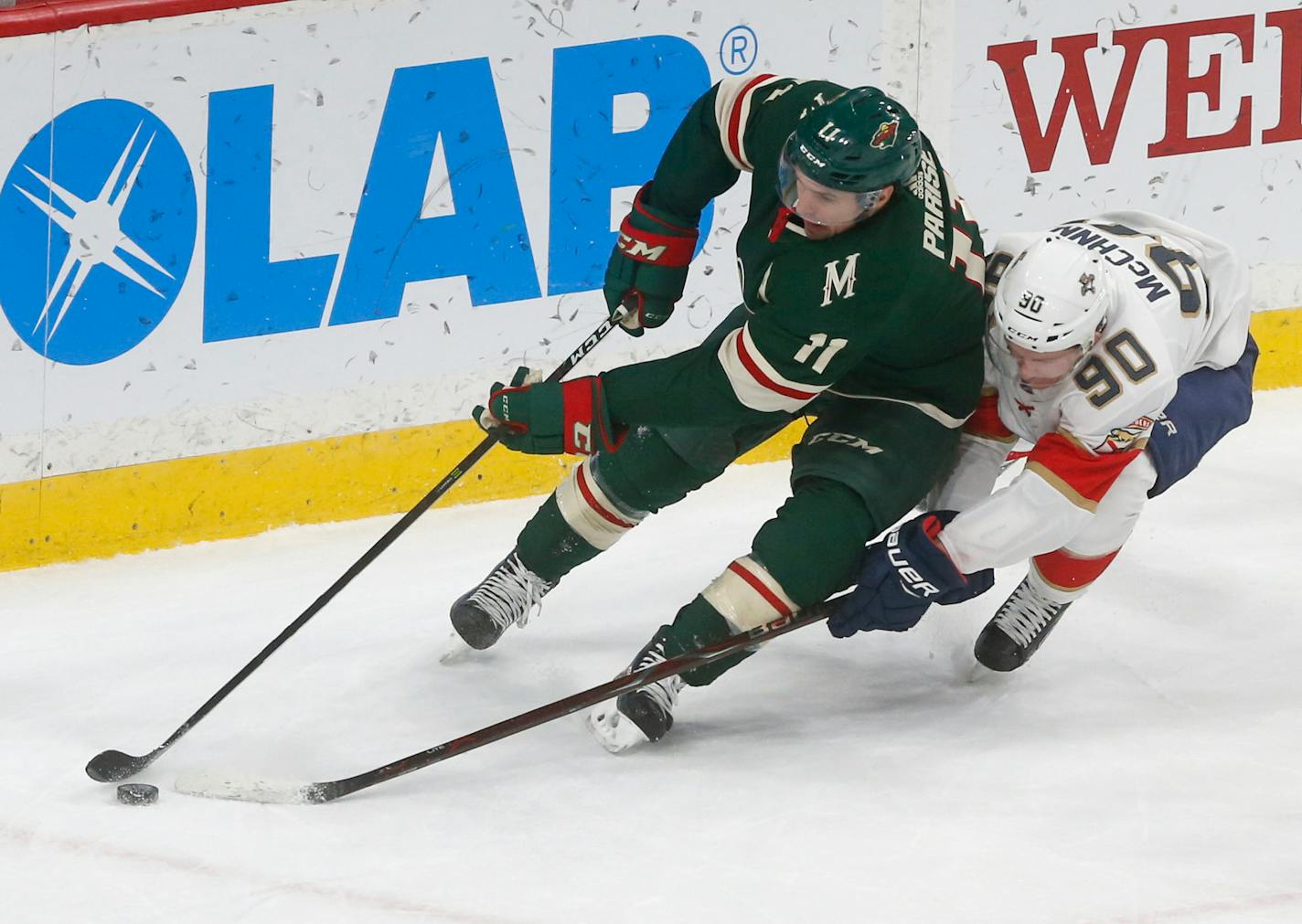 Florida Panthers' Jared McCann, right, tries to reach the puck as he pursues Minnesota Wild's Zach Parise during the first period of an NHL hockey game Tuesday, Jan. 2, 2018, in St. Paul, Minn. It was Parise's first game this season after recovering from back surgery.