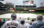 Minnesota Twins fans watched from under plastic rain ponchos as a Jimmy Buffet cover band entertained the crowd during a rain delay Friday at Target F