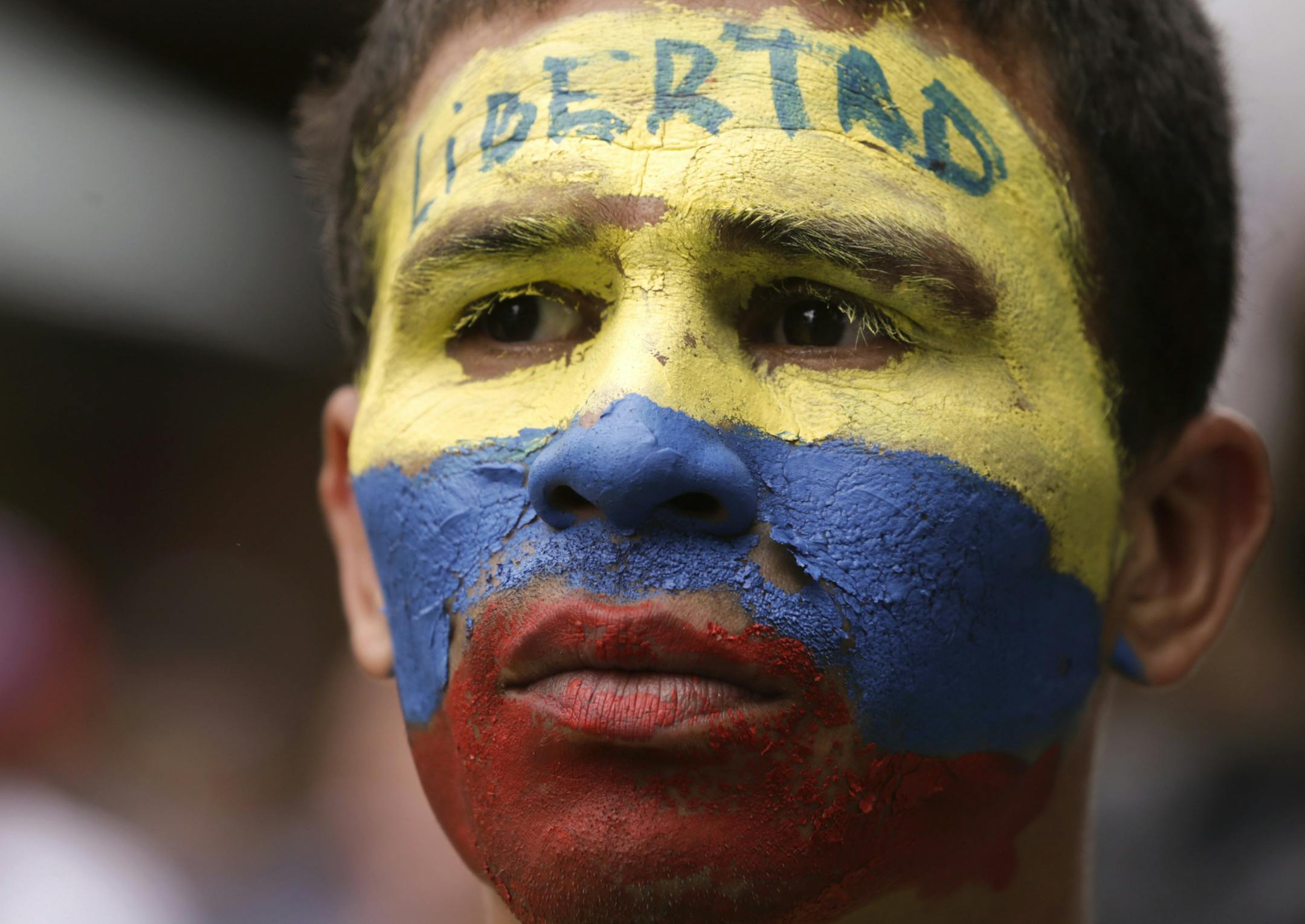 An opponent to Venezuela's President Nicolas Maduro, his face painted the colors of the Venezuelan national flag and with the Spanish word for "Freedom" written on his forehead, takes part in a march in Caracas, Venezuela, Saturday, May 4, 2019. Opposition leader Juan Guaido took his quest to win over Venezuela's troops back to the streets, calling his supporters to participate in an outreach to soldiers outside military installations across the country. (AP Photo/Martin Mejia)