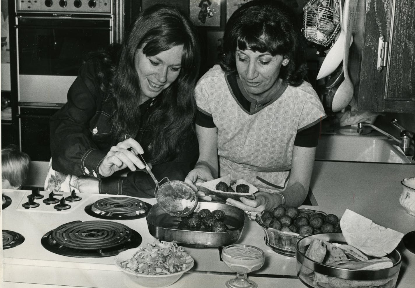 Mrs. Abraham Degani, left, and Mrs. Benjamin Lowenberg make falafel, a vegetable croquette. 1971 Star Tribune file photo. For Taste 40.