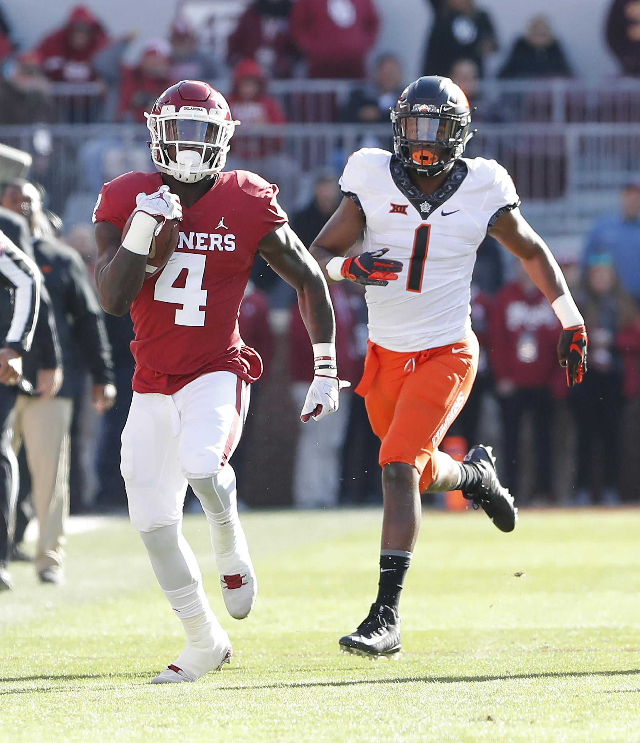 Oklahoma running back Trey Sermon (4) runs ahead of Oklahoma State linebacker Calvin Bundage (1) in the first quarter of an NCAA college football game in Norman, Okla., Saturday, Nov. 10, 2018. (AP Photo/Alonzo Adams)
