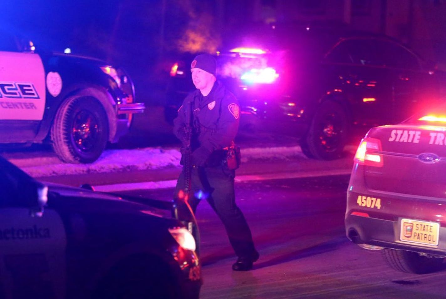 An armed police officer walked near the scene of an active shooting Friday, Feb. 12, 2016, in Plymouth, MN.