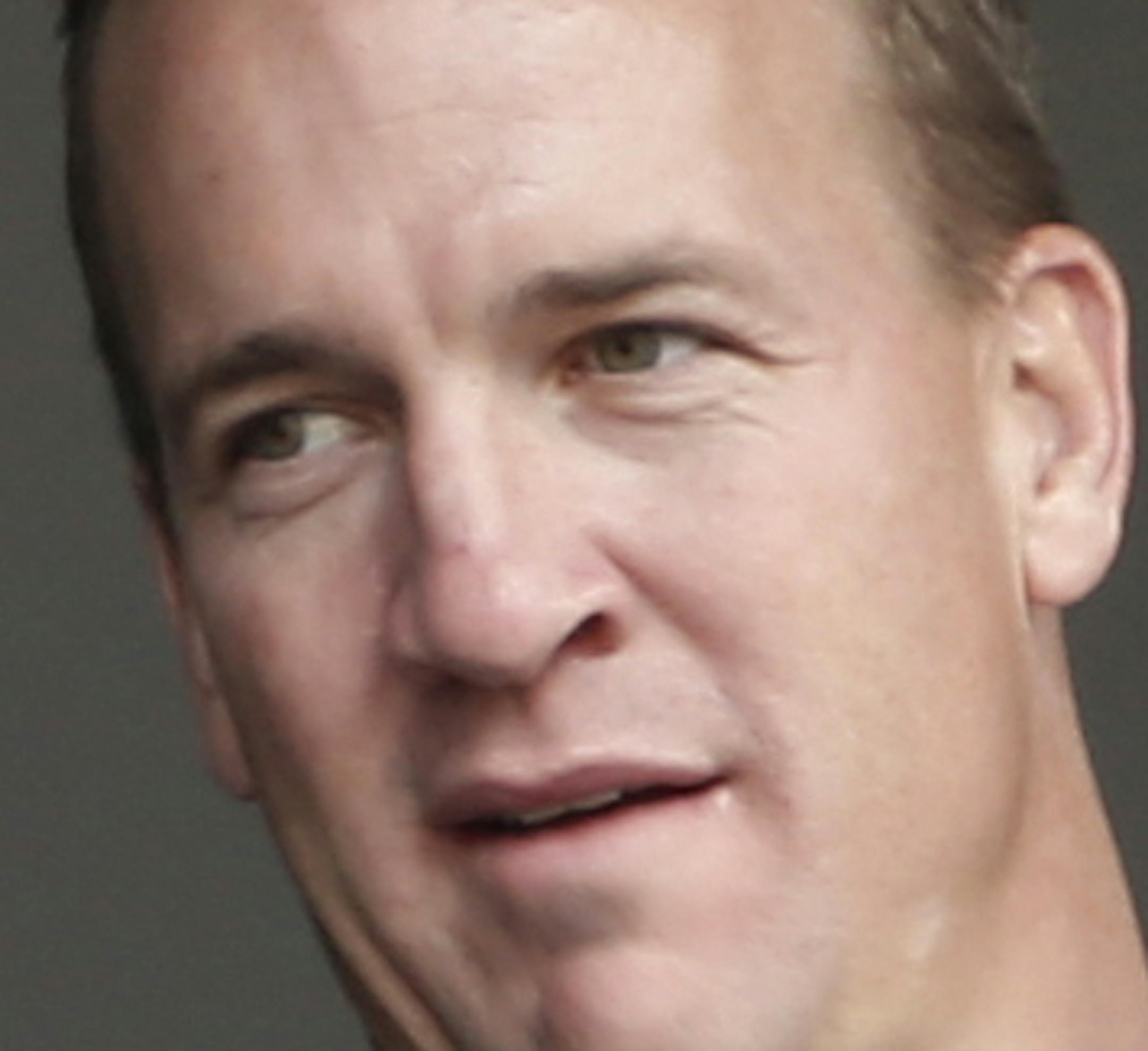 FILE - In this May 4, 2014, file photo, Denver Broncos quarterback Peyton Manning, right, points out something in the stadium to his brother, New York Giants quarterback Eli Manning, from New York Yankees' Derek Jeter's suite during a baseball game between the Yankees and the Tampa Bay Rays at Yankee Stadium in New York. Peyton Manning had a little fun with little brother Eli's sad face at the Super Bowl during an appearance on NBC's "Tonight Show." (AP Photo/Kathy Willens, File)