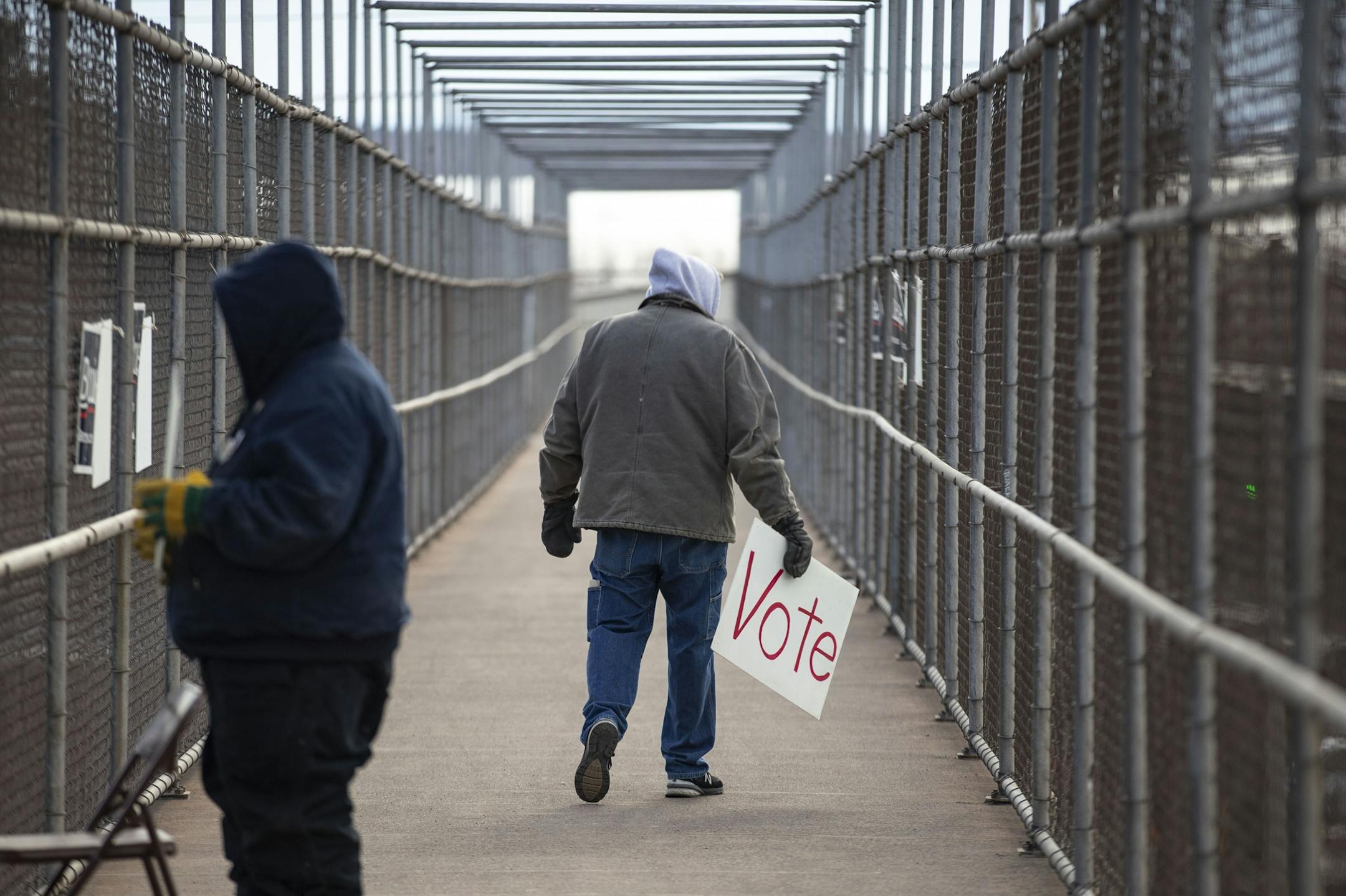 (Left) Mike Kuitu and Jerry Witte held up signs urging people to vote for Bernie Sanders on a foot bridge overlooking I-35 in Duluth, MN on Tuesday morning.