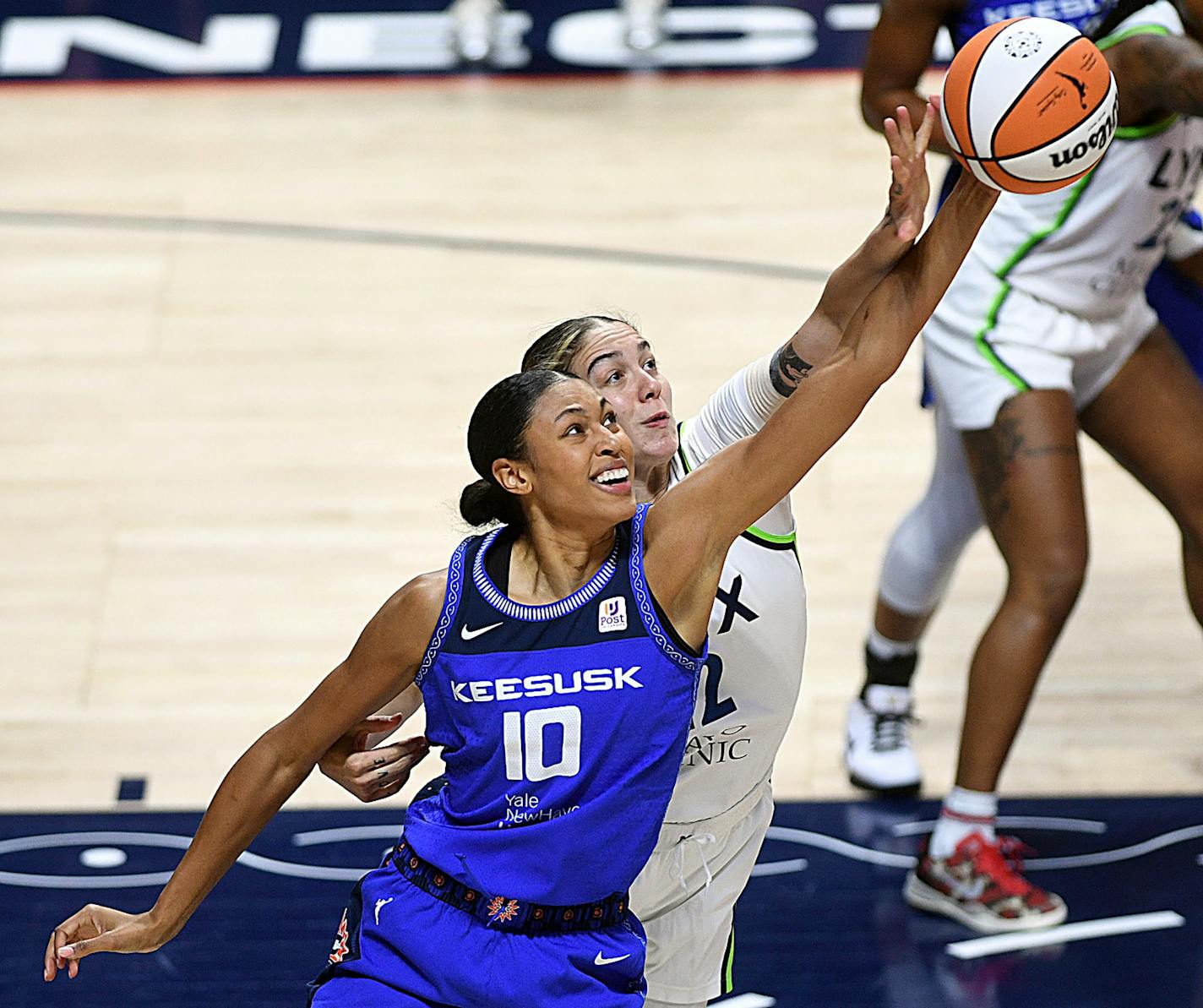 Connecticut Sun's Olivia Nelson-Ododa (10) and Minnesota Lynx's Emily Engstler (22) reach for a pass during a WNBA basketball game on Tuesday, Aug. 1, 2023 at Mohegan Sun Arena in Uncasville, Conn. (Sarah Gordon/The Day via AP)