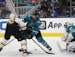 Boston Bruins left wing Jake DeBrusk (74) battles for the puck against San Jose Sharks defenseman Jacob Middleton (21) as Sharks goaltender James Reim