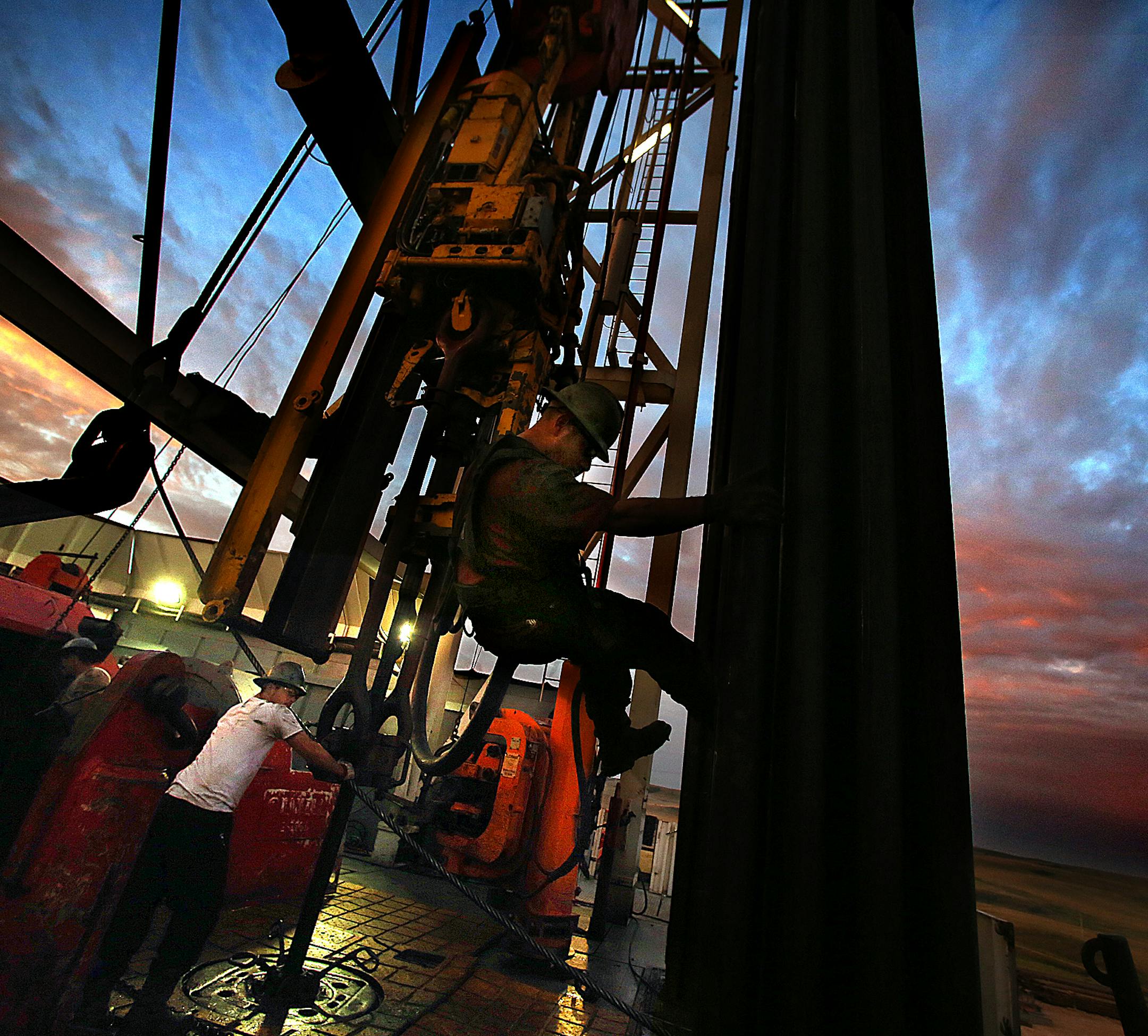 Derrick hand Scott Berreth (right) rappelled through the drilling rig structure as the crew prepared to restart machinery after some repairs had been made earlier in the morning. ] (JIM GEHRZ/STAR TRIBUNE) / December 17, 2013, Watford City, ND &#x201a;&#xc4;&#xec; BACKGROUND INFORMATION- PHOTOS FOR USE IN FINAL PART OF NORTH DAKOTA OIL BOOM PROJECT: Men work around the clock at Raven Rig No. 1 near Watford City, one of nearly 200 towering oil rigs in the Bakken. Once the rigs drill holes, severa