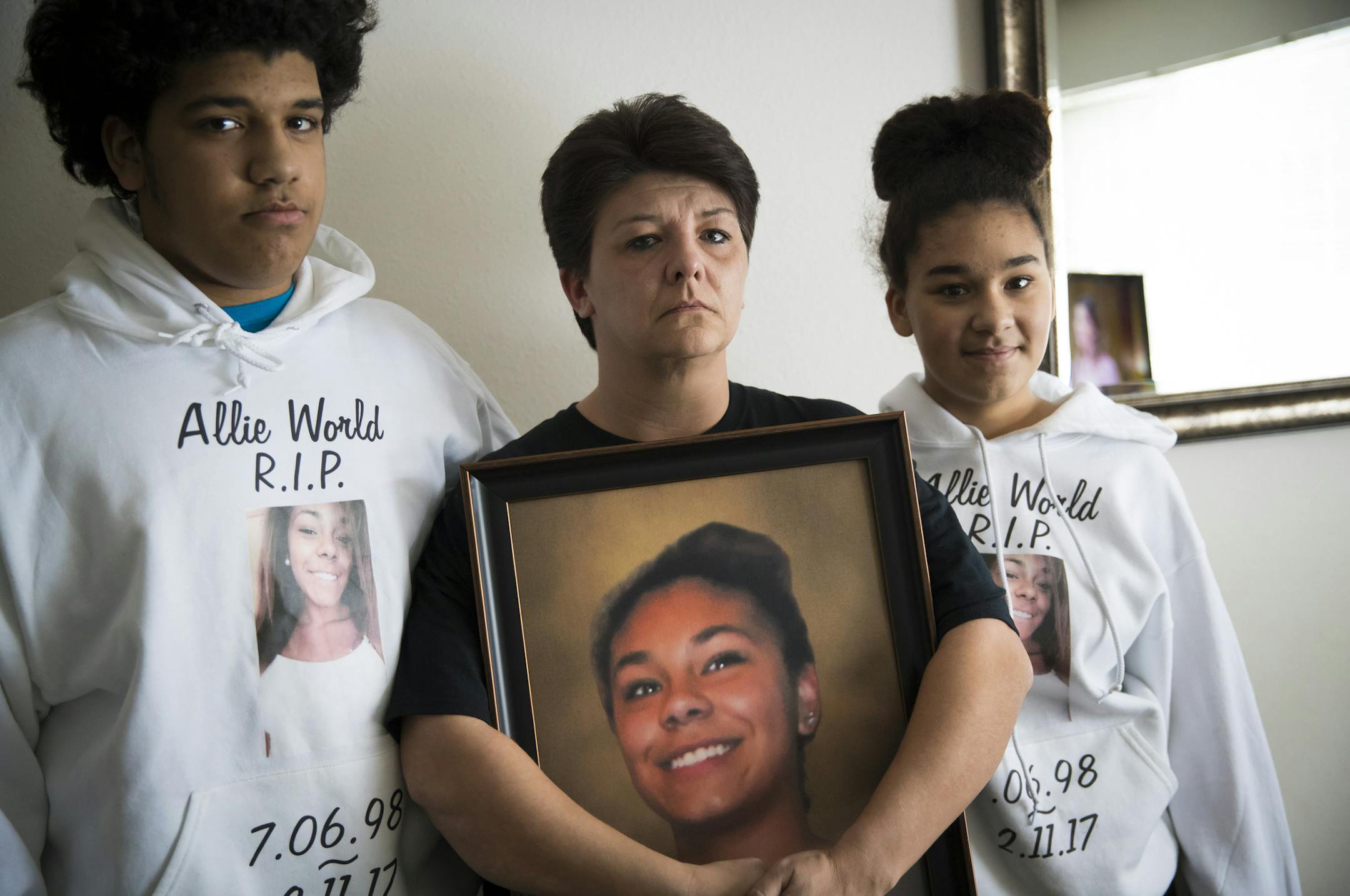 Pictured from the left; Brother Major “Zach Campbell, 15, mom Heidi Campbell and sister Madison Campbell, 12, all wearing shirts with pictures of their sister and daughter Allie Campbell,who died in a shooting on February 11, posed with her picture at home on Wednesday, March 1, 2017, in St. Cloud, Minn.