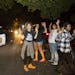 Protesters stand with their hands up on the street outside Falcon Heights Mayor Peter Lindstrom's home as St. Anthony Police watch them from their car