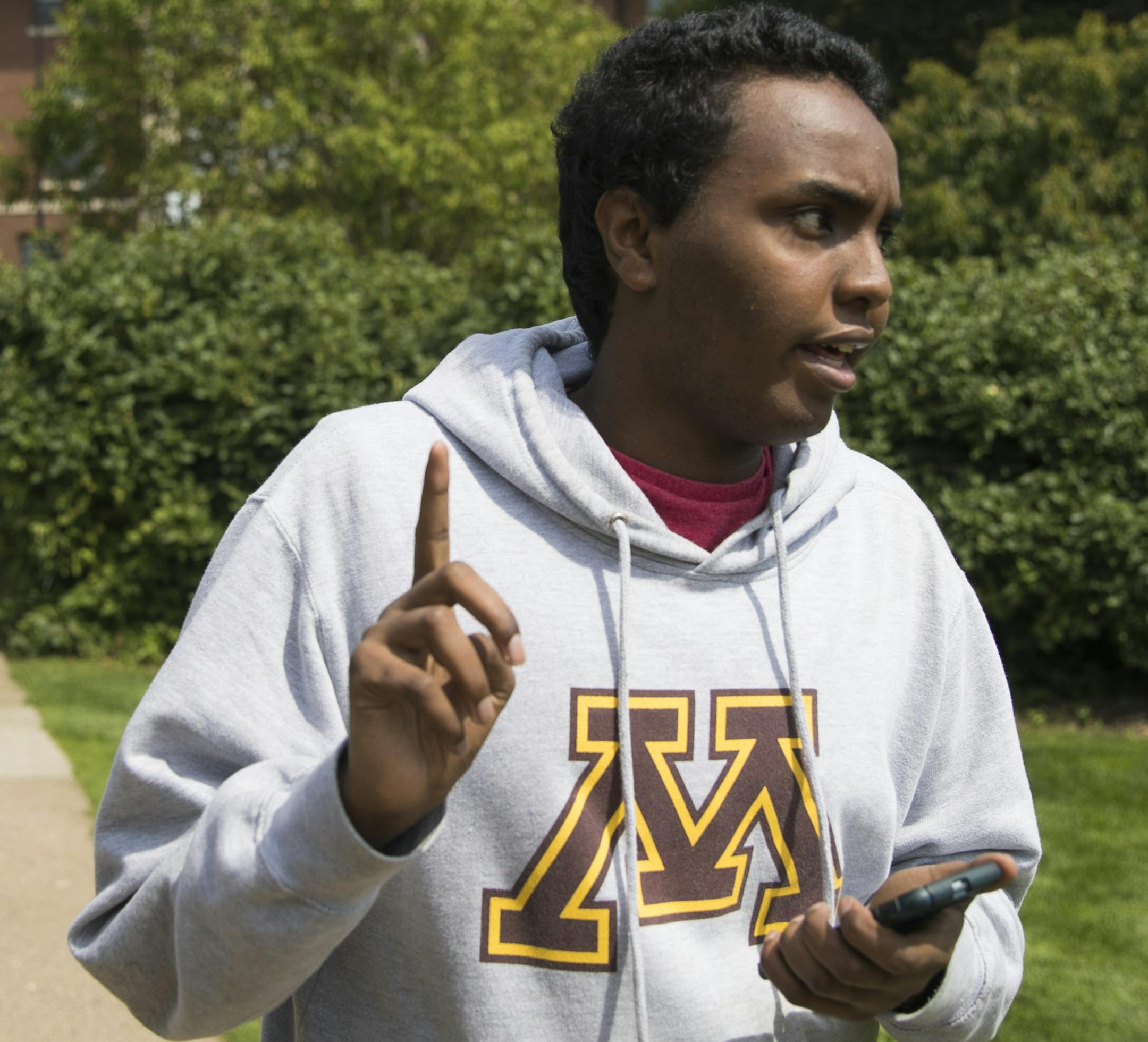 Mohamed Hassan wore his hopes for the future on his University of Minnesota hoodie. Top: Hassan embraced his older sister, Ifrah, after his Roosevelt High graduation.