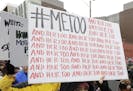 FILE - In this Jan. 20, 2018 file photo, a marcher carries a sign with the popular Twitter hashtag #MeToo used by people speaking out against sexual h