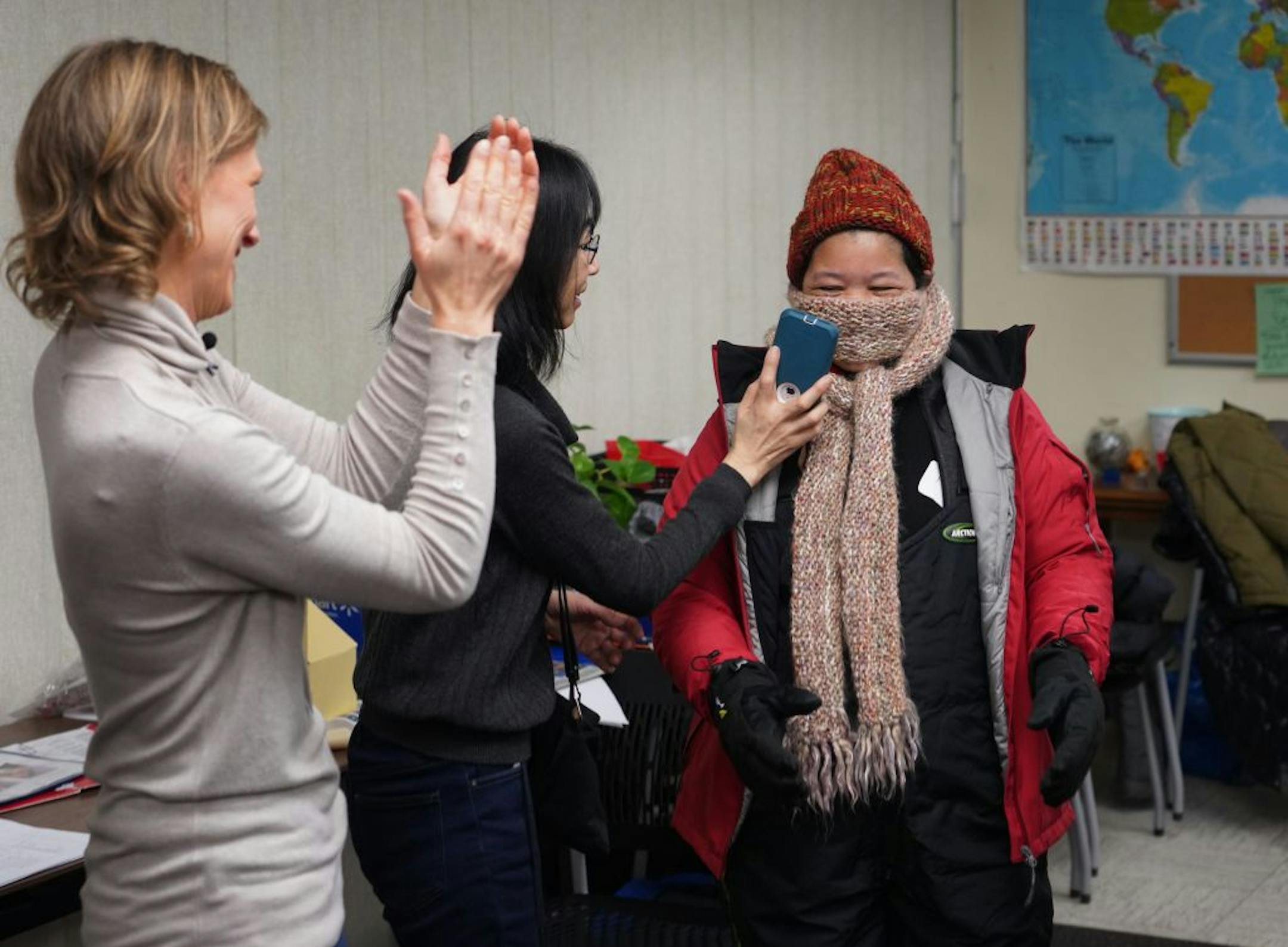 St. Paul nonprofit International Institute of MN helps new Americans make the transition to life in the United States. Among the services they offer is a series of classes titled "Live in MN", that includes everyting from how to navigate the legal system and gain employment as well as Mn-specific education such as how to shovel and dress for winter. Here, Sara Skinner claps as Prae Meh, a new immigrant from Burma, gets dressed up in her Minnesota winter gear.