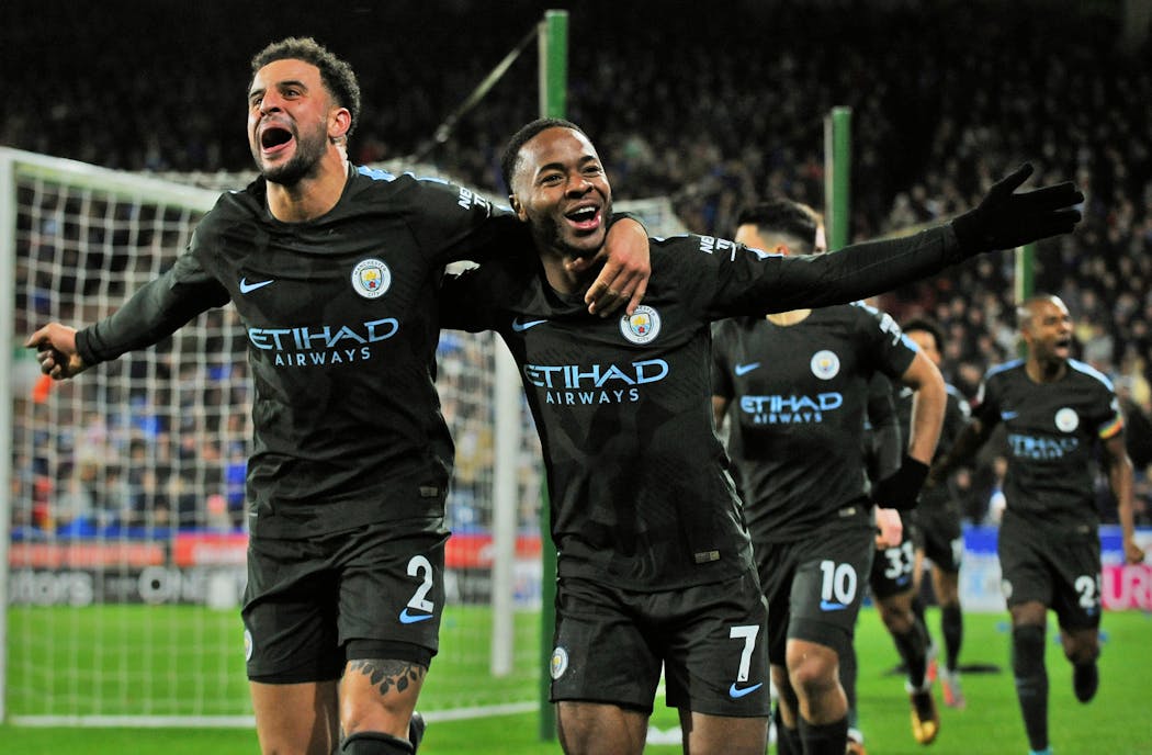 Manchester City's Raheem Sterling, right, celebrated with teammate Kyle Walker after scoring during the English Premier League soccer match between Huddersfield Town and Manchester City in Huddersfield, England, on Sunday. Man City equaled a club record with its 11th consecutive league victory.