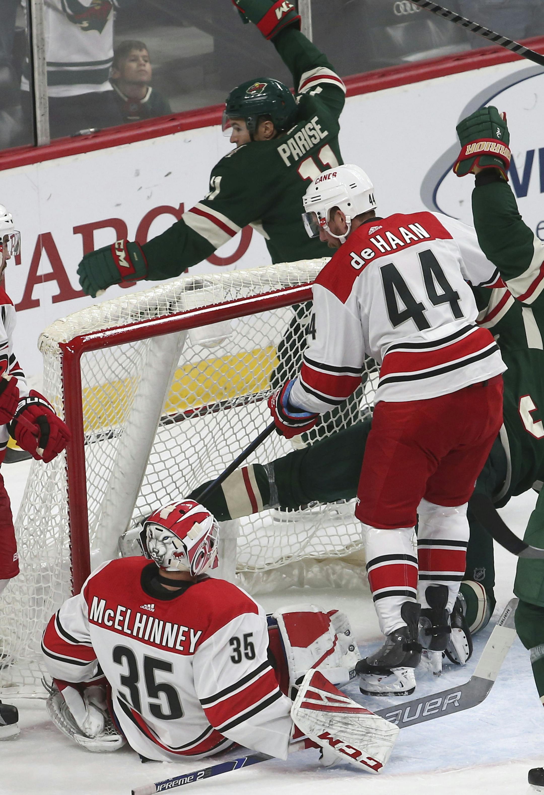 CORRECTS CREDIT FOR GOAL TO CHARLIE COYLE - Minnesota Wild's Zach Parise, top center, celebrates a power-play goal by Charlie Coyle against Carolina Hurricanes goalie Curtis McElhinney, lower left, during the first period of an NHL hockey game Saturday, Oct. 13, 2018, in St. Paul, Minn. (AP Photo/Jim Mone)