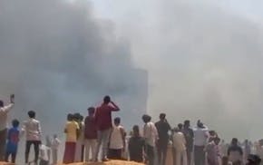 People watch smoke rising after an airplane crashed in Ahmedabad, Gujarat state, India, Thursday, June 12, 2025. (Mohan Nakum via AP)