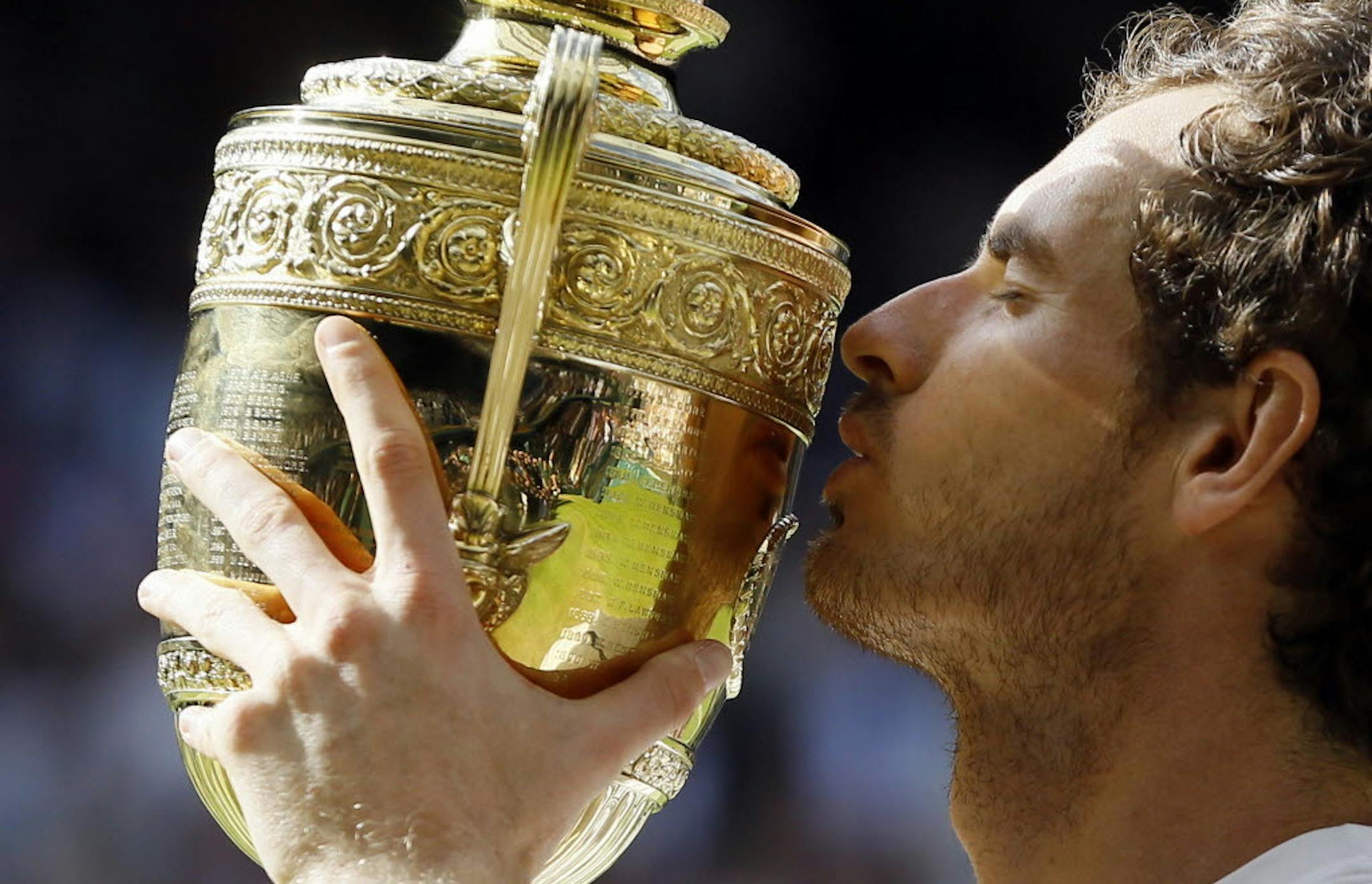 Andy Murray of Britain kisses the trophy after beating Milos Raonic of Canada in the men's singles final on day fourteen of the Wimbledon Tennis Championships in London, Sunday, July 10, 2016. (AP Photo/Kirsty Wigglesworth)
