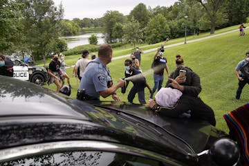 A Minneapolis Parks police officer sprays mace after protestors and homeless advocates blocked the path of a police cruiser attempting to evacuate the