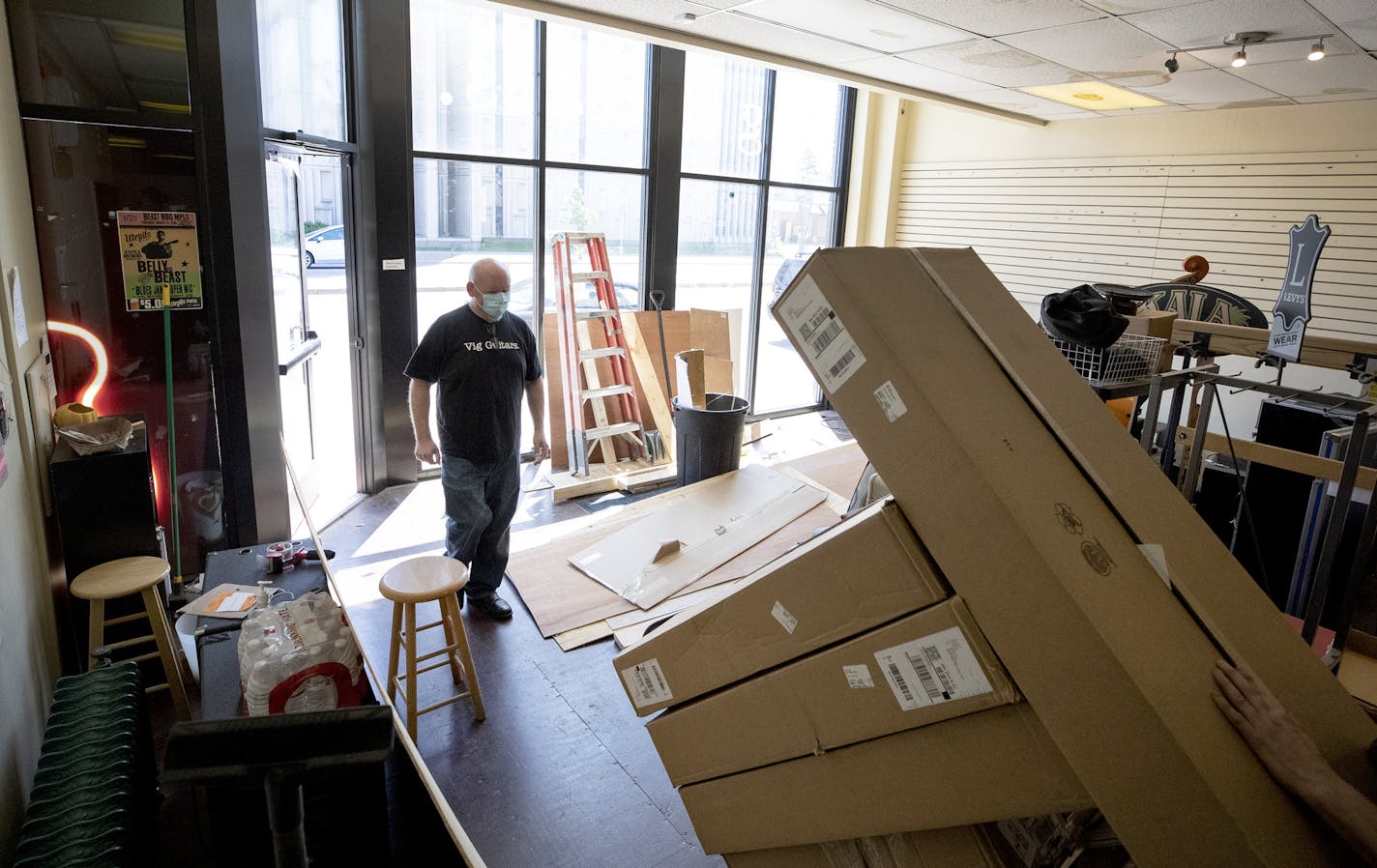 Ted Vig accepted a delivery from UPS at Vig's guitars in St. Paul. The store windows had just been replaced after the store was looted in late May.