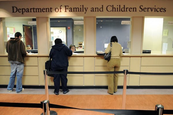File photo: People wait in line to apply for benefits, including Medicaid and food stamps, at the Department of Family and Childrens Services in Lawre