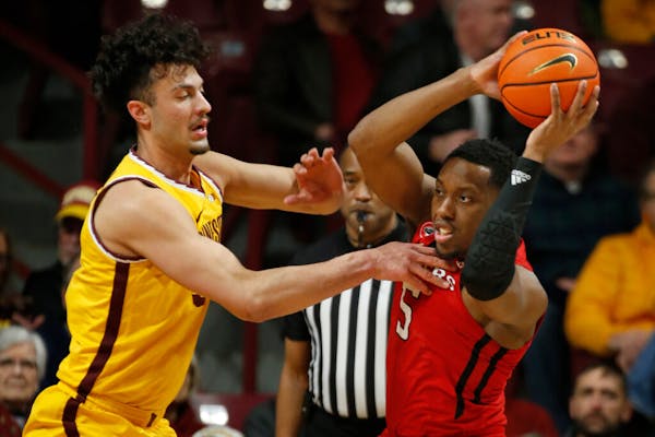 Rutgers forward Aundre Hyatt (5) looks to pass the ball as Minnesota forward Dawson Garcia defends during the first half of an NCAA college basketball
