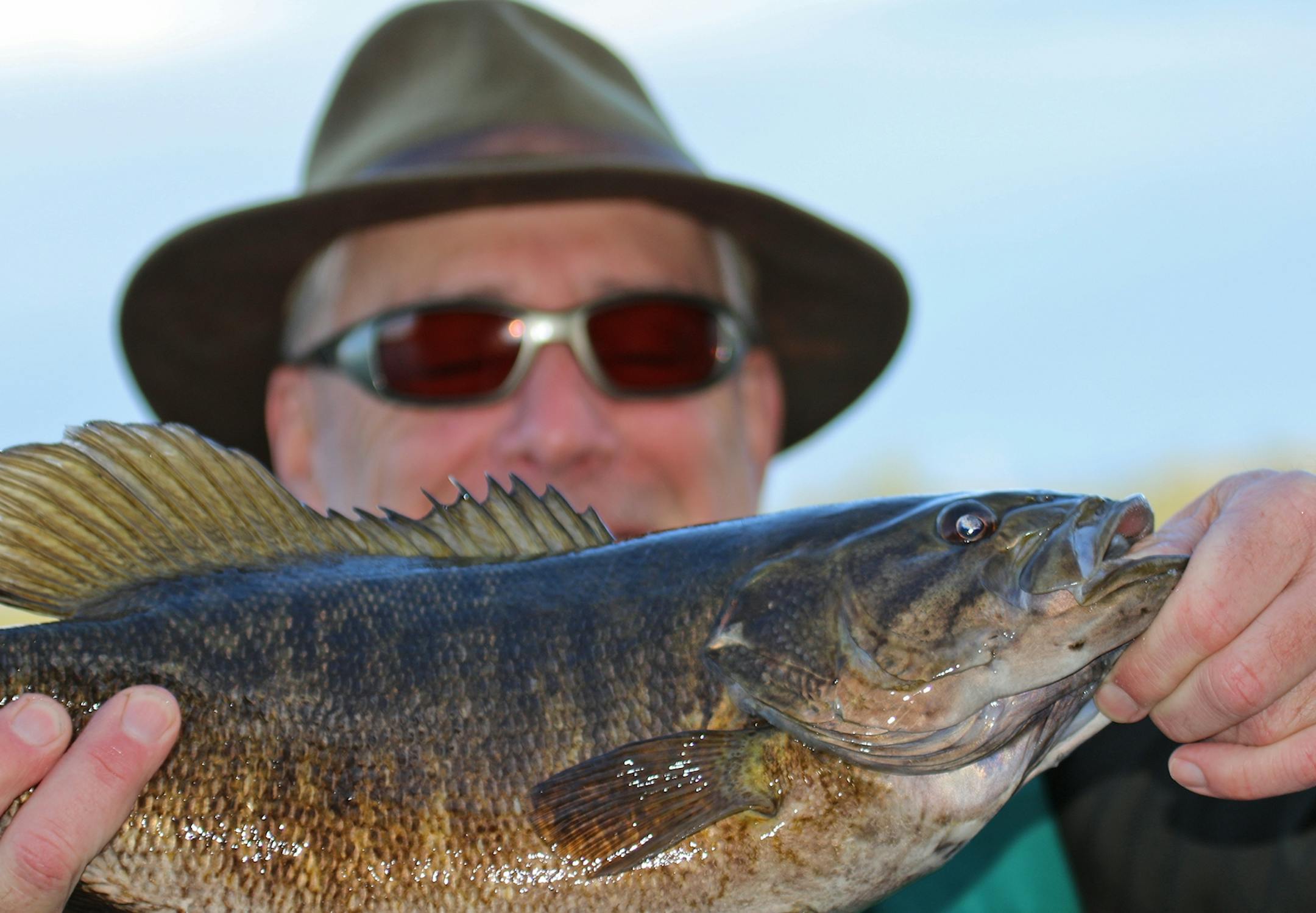 Bill Spohn of Duluth hoists a heft smallmouth bass caught in Quetico Provincial Park in late April, just after the ice went out.