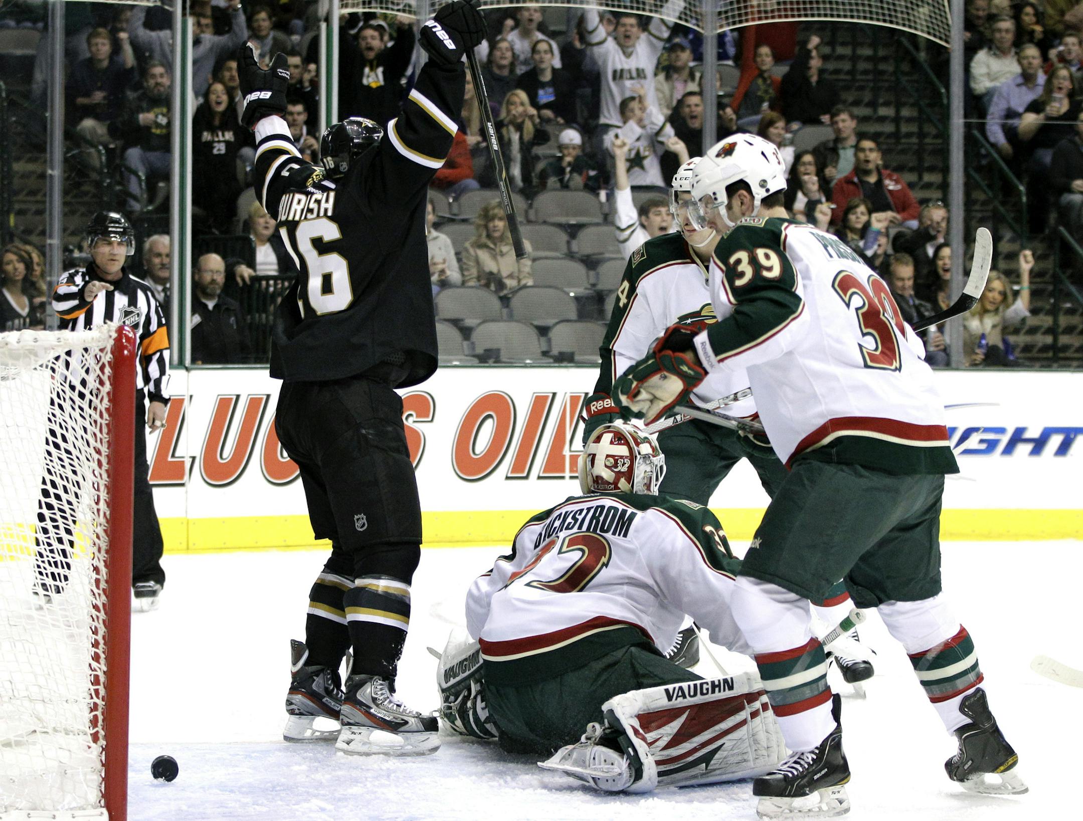 Dallas Stars' Adam Burish (16) celebrates a goal by teammate Tom Wandell against Minnesota Wild's Niklas Backstrom (32), of Finland, as the Wild's Nate Prosser (39) looks on in the first period of an NHL hockey game Friday, Feb. 24, 2012, in Dallas. (AP Photo/Tony Gutierrez) ORG XMIT: DNA102