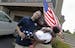 Afghanistan veteran Jason Smith and his wife Trizer Smith and their daughter Imani, 15 months, held a flag and a key to their new home, Thursday, June