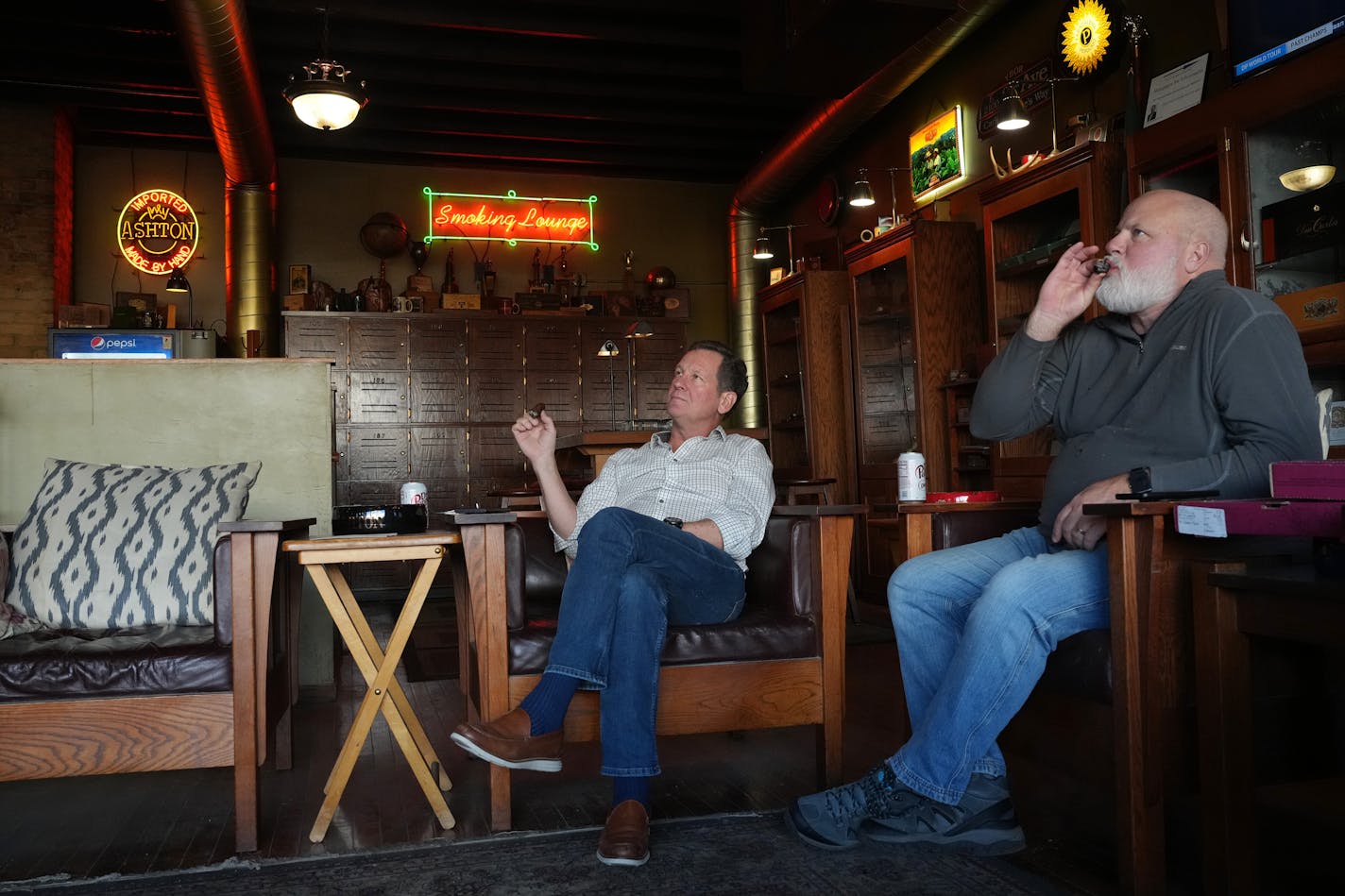 Friends Joe Blauert, left, of St. Paul, and Scott Johnson of Carver enjoy cigars Wednesday, Nov. 29, 2023 in the smoking lounge at Anthony's Pipe and Cigar Lounge in south Minneapolis. A Minneapolis City Council committee Wednesday approved an effort to tighten the city's tobacco ordinance, but the move might effectively kill the city's only remaining public cigar lounge. The move is part of a wider anti-tobacco effort that would also outlaw and discounts or coupons on cigarettes. ] ANTHONY SOUFFLE • anthony.souffle@startribune.com