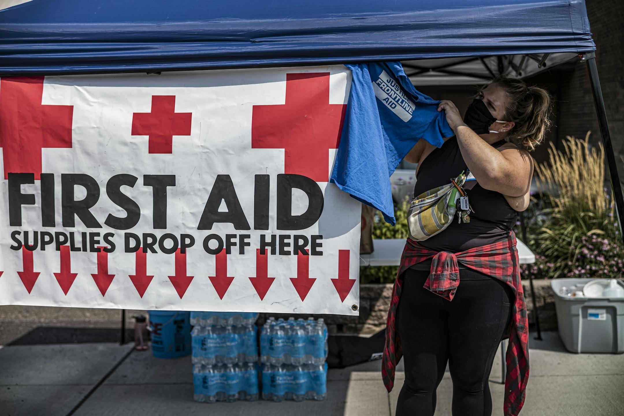 Volunteer Courtney Strasburg accepts donations of backpacks and bottled water for Justice Frontline Aid. Founder Zeshann Sanchez will be heading out to Kenosha, Wisconsin to join the protests there. The backpacks donated or purchased with donations will be used for first aid kits.