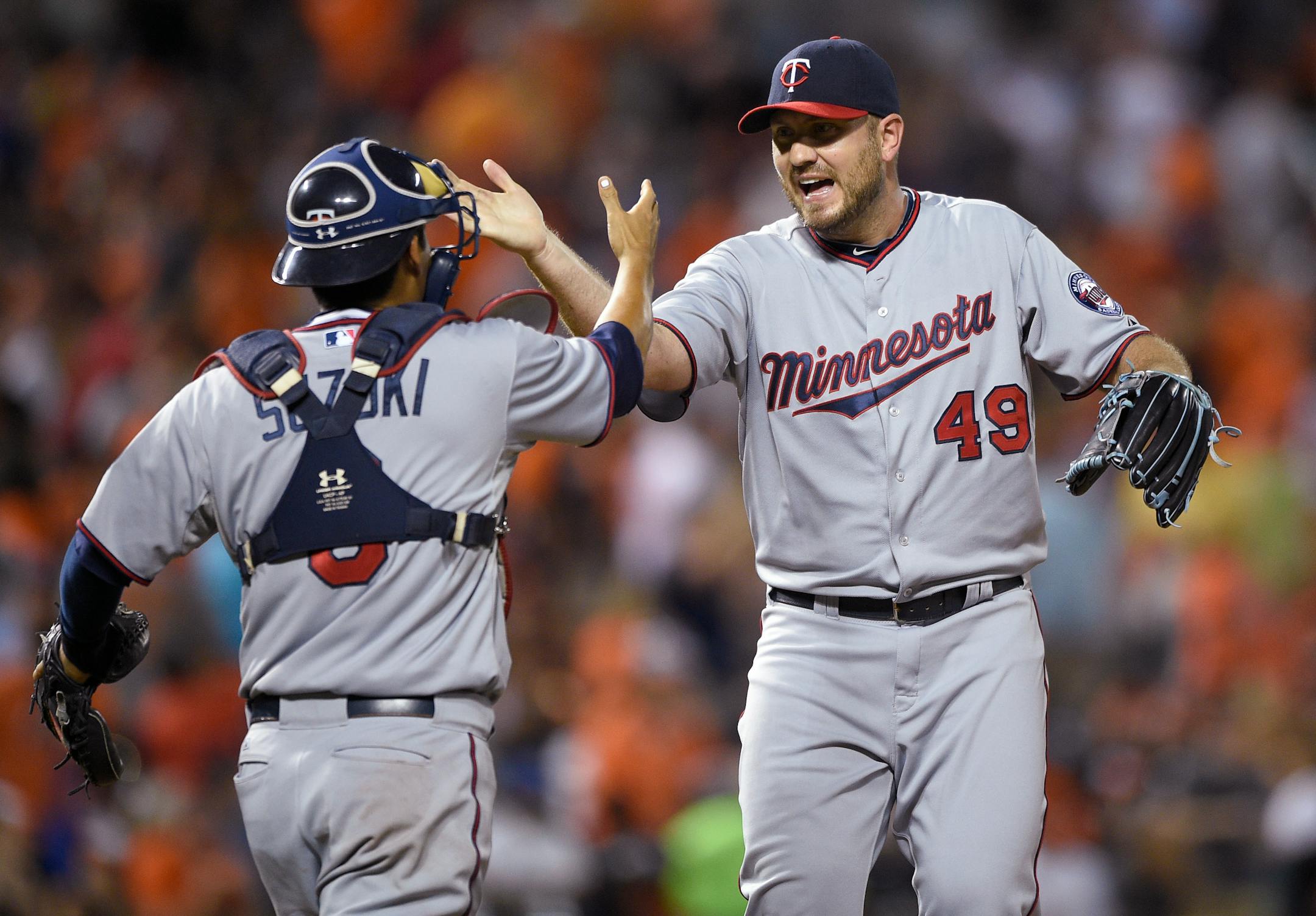 Minnesota Twins relief pitcher Kevin Jepsen (49) celebrates with catcher Kurt Suzuki, left, after the Twins defeated the Baltimore Orioles 3-2 in a baseball game, Saturday, Aug. 22, 2015, in Baltimore. (AP Photo/Nick Wass)